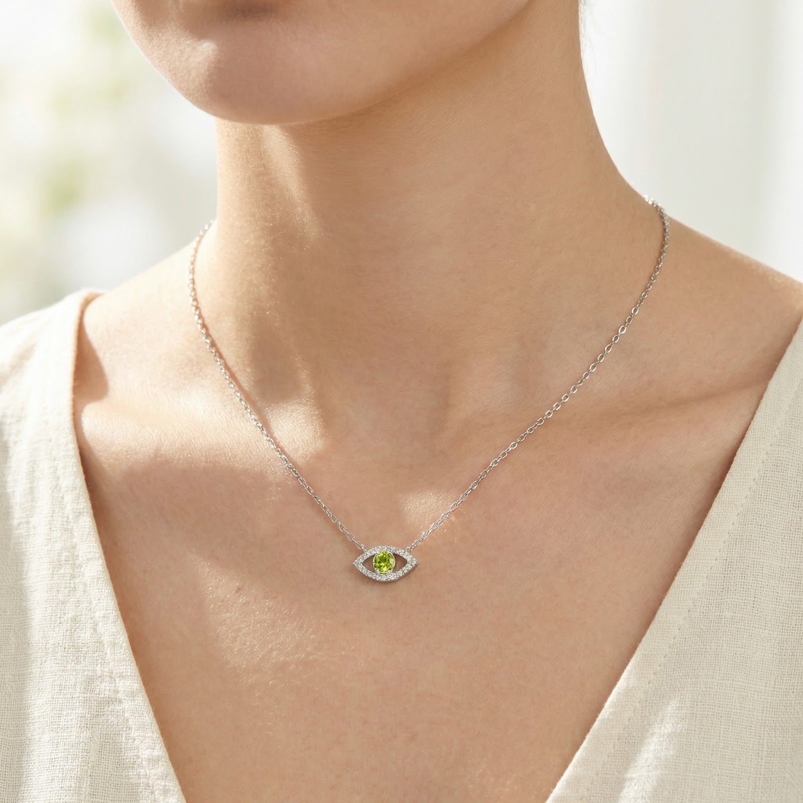 Model wearing the silver Azurise Eye necklace with a round cut yellow-green moissanite birthstone.