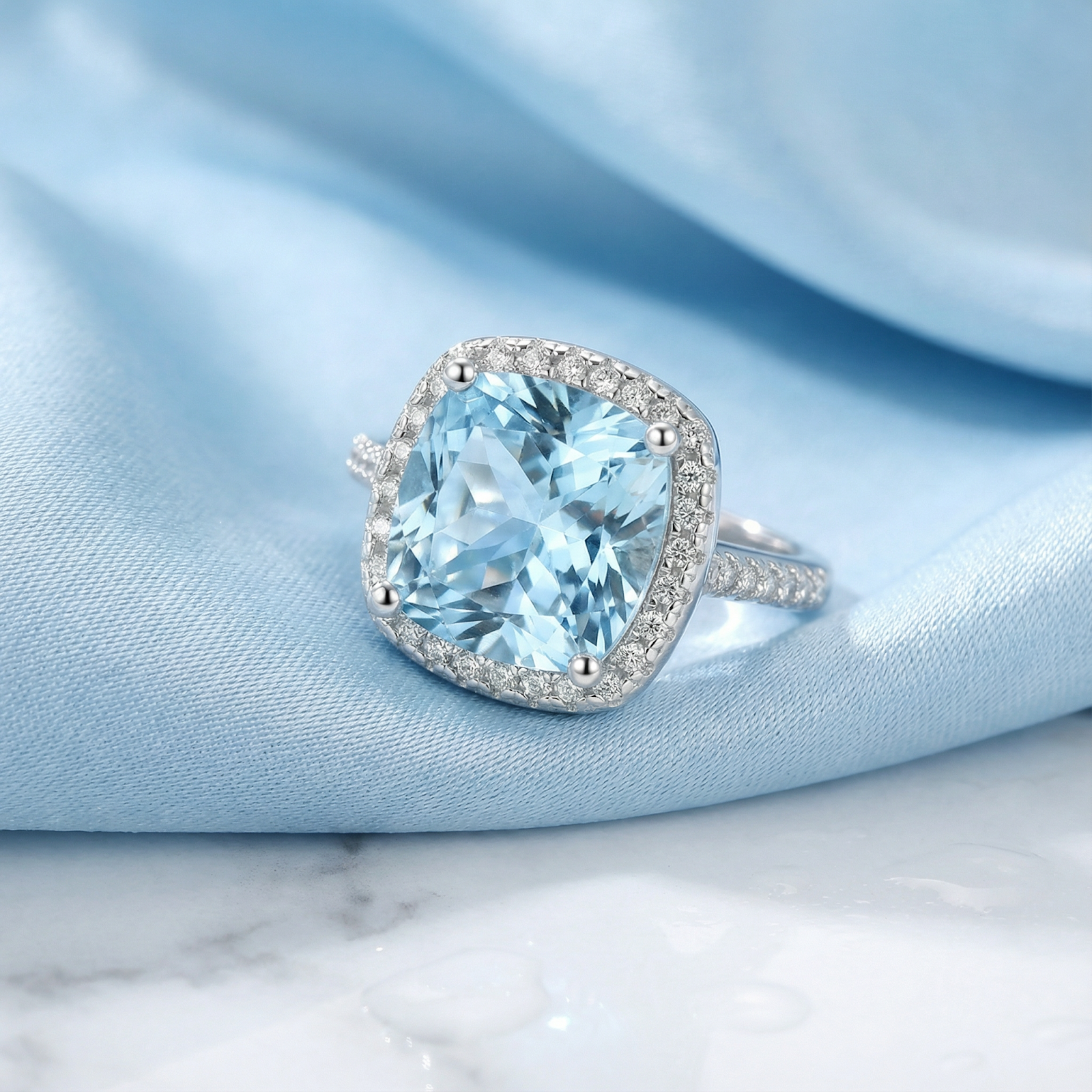 Macro view of the cushion-cut simulated aquamarine and halo setting on a sterling silver band.