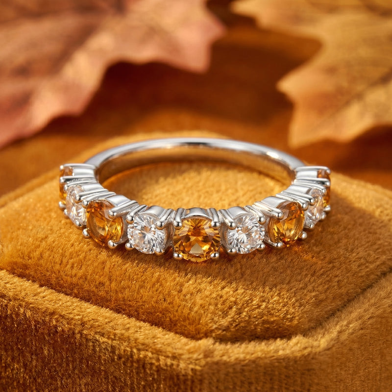 Macro shot of the Novara sterling silver band's round honey simulated topaz stones in a low-profile prong setting.