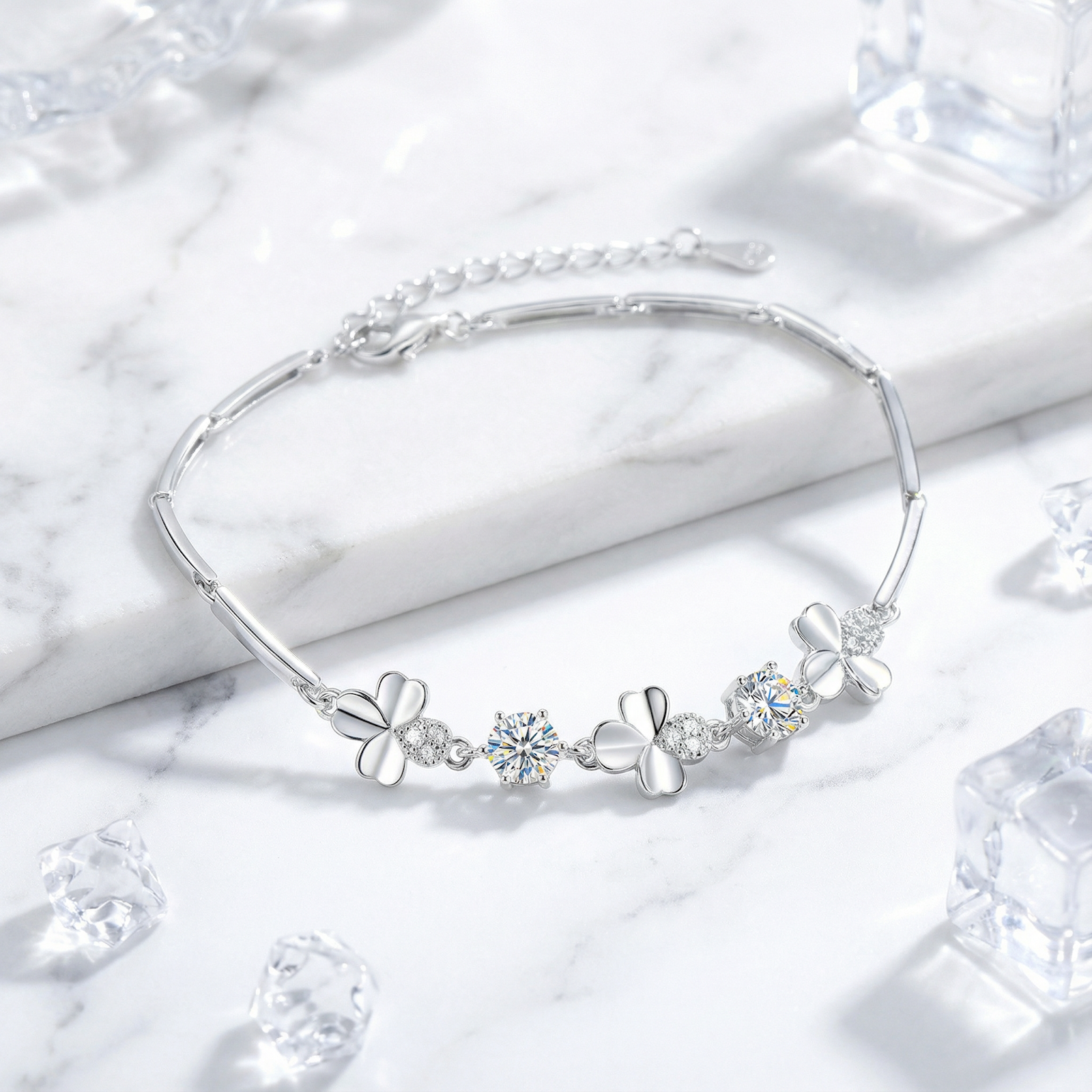 S925 sterling silver clover bracelet with round-cut simulated diamonds on a marble surface with ice cubes.
