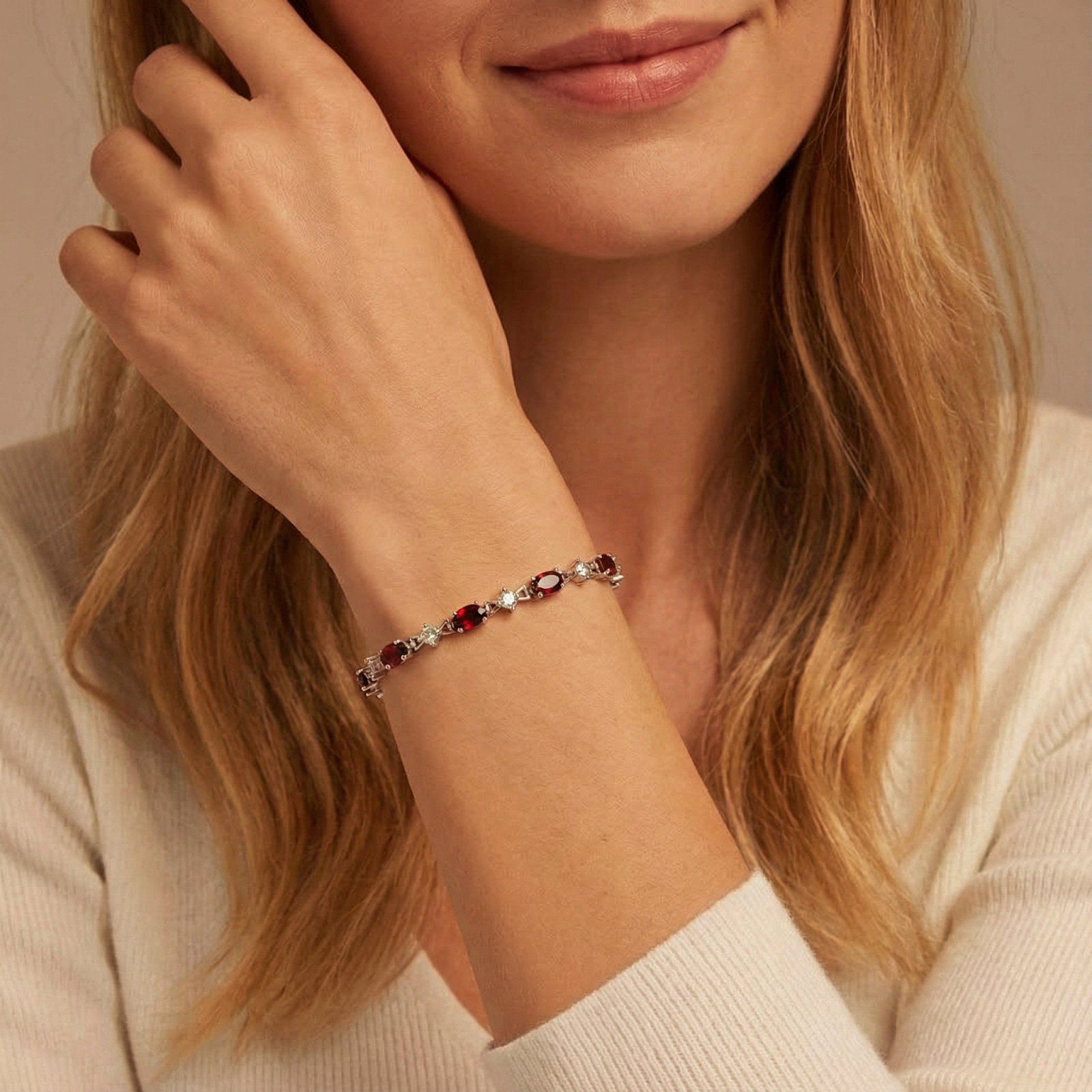 Model wearing the sterling silver Rosabella station bracelet with oval red simulated garnets on her wrist.