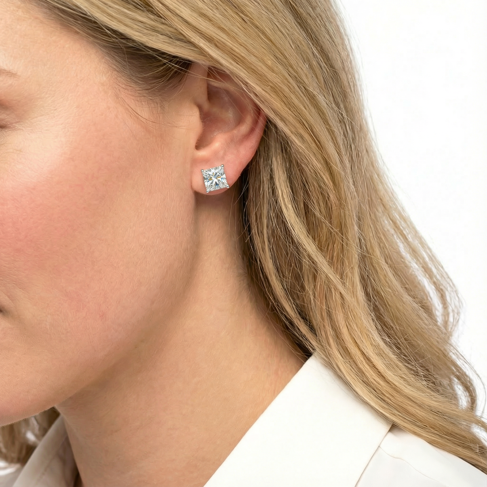 Side view of a model wearing the Clarisse princess cut zirconia stud earring in 18K rose gold vermeil.
