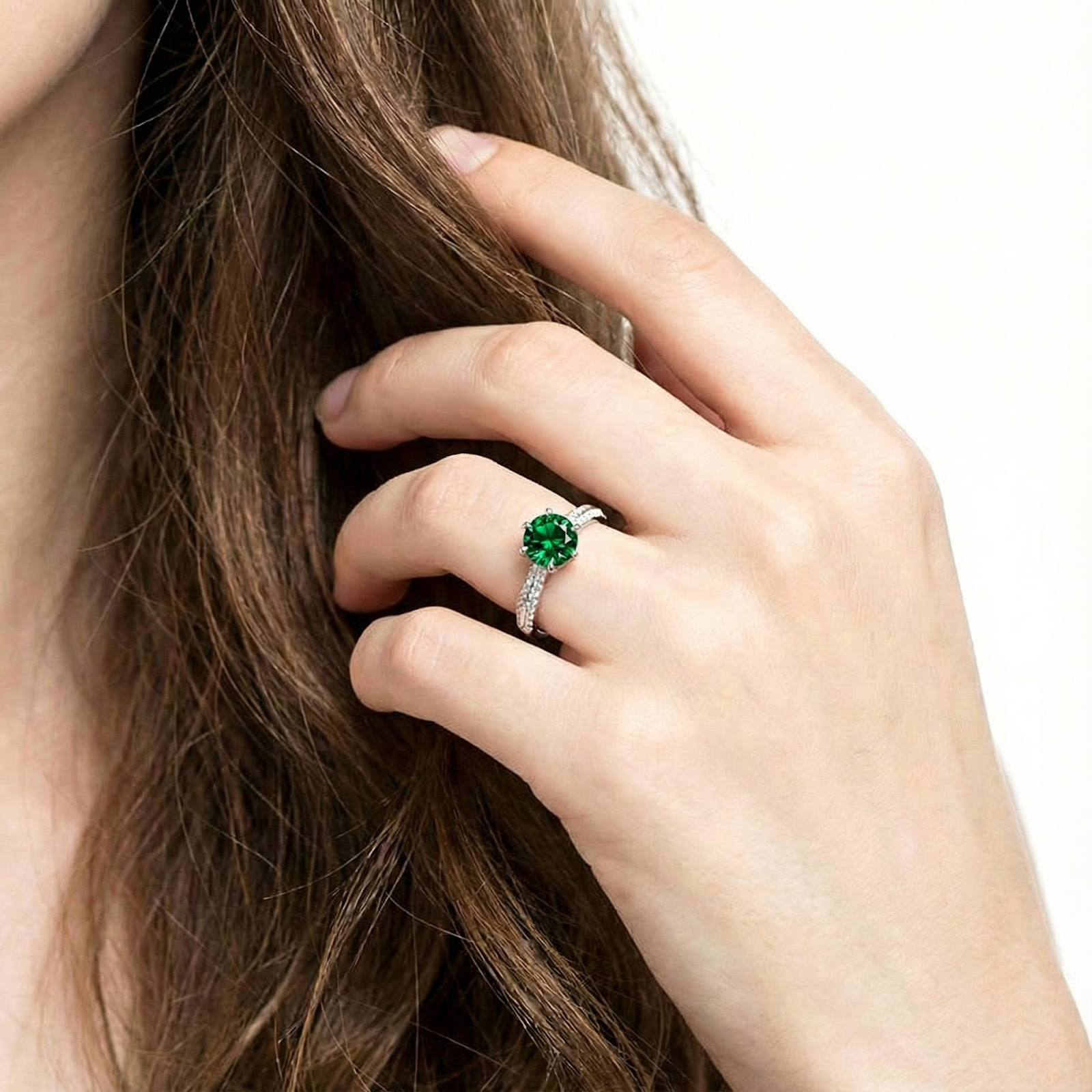 Forest green round simulated emerald halo ring in S925 sterling silver shown on a model's hand.