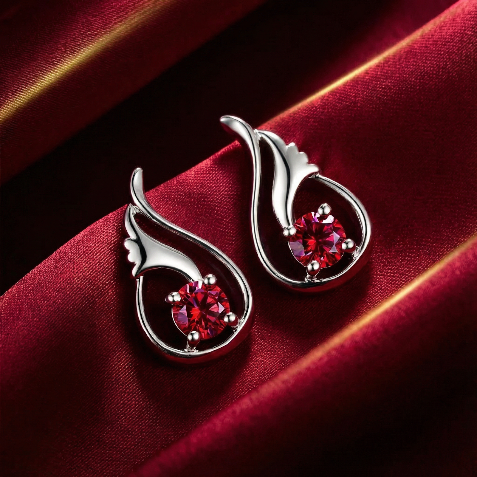Close-up of round cut simulated ruby earrings in platinum vermeil sterling silver showing stone facets.