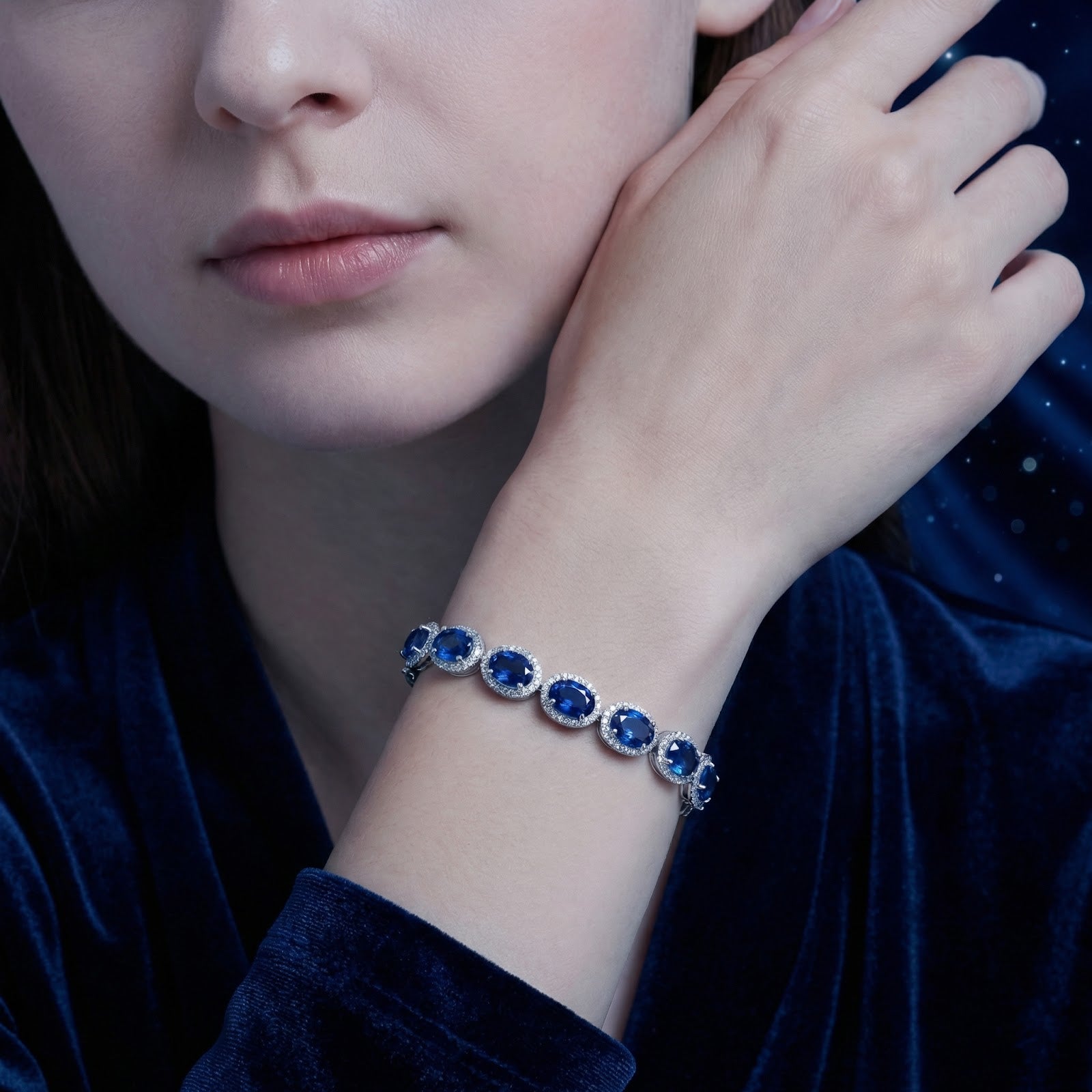 Model wearing the Mirelisse halo bracelet with oval simulated sapphires in sterling silver on her wrist.