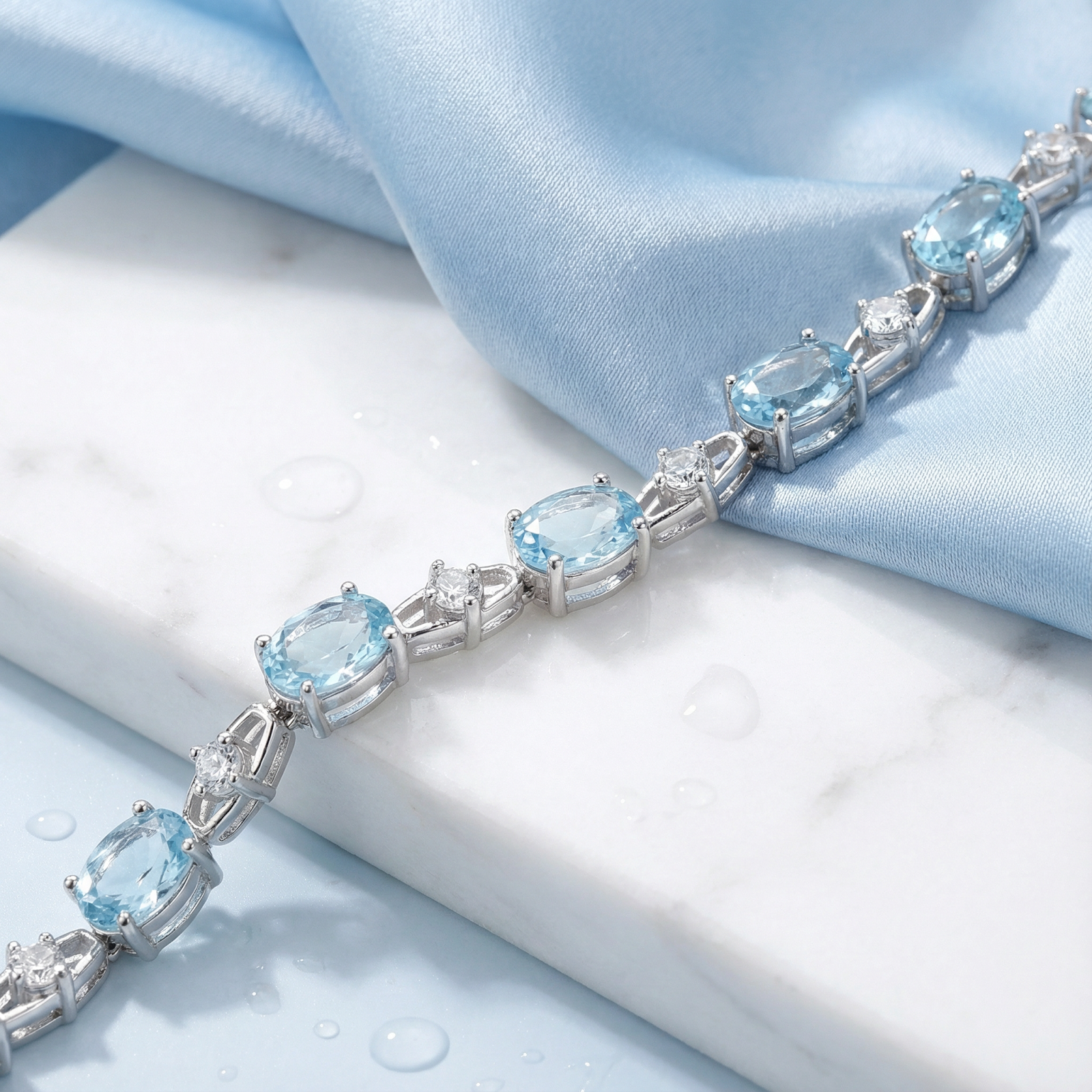 Close-up detail of oval cut simulated aquamarine stones in a sterling silver bracelet setting.