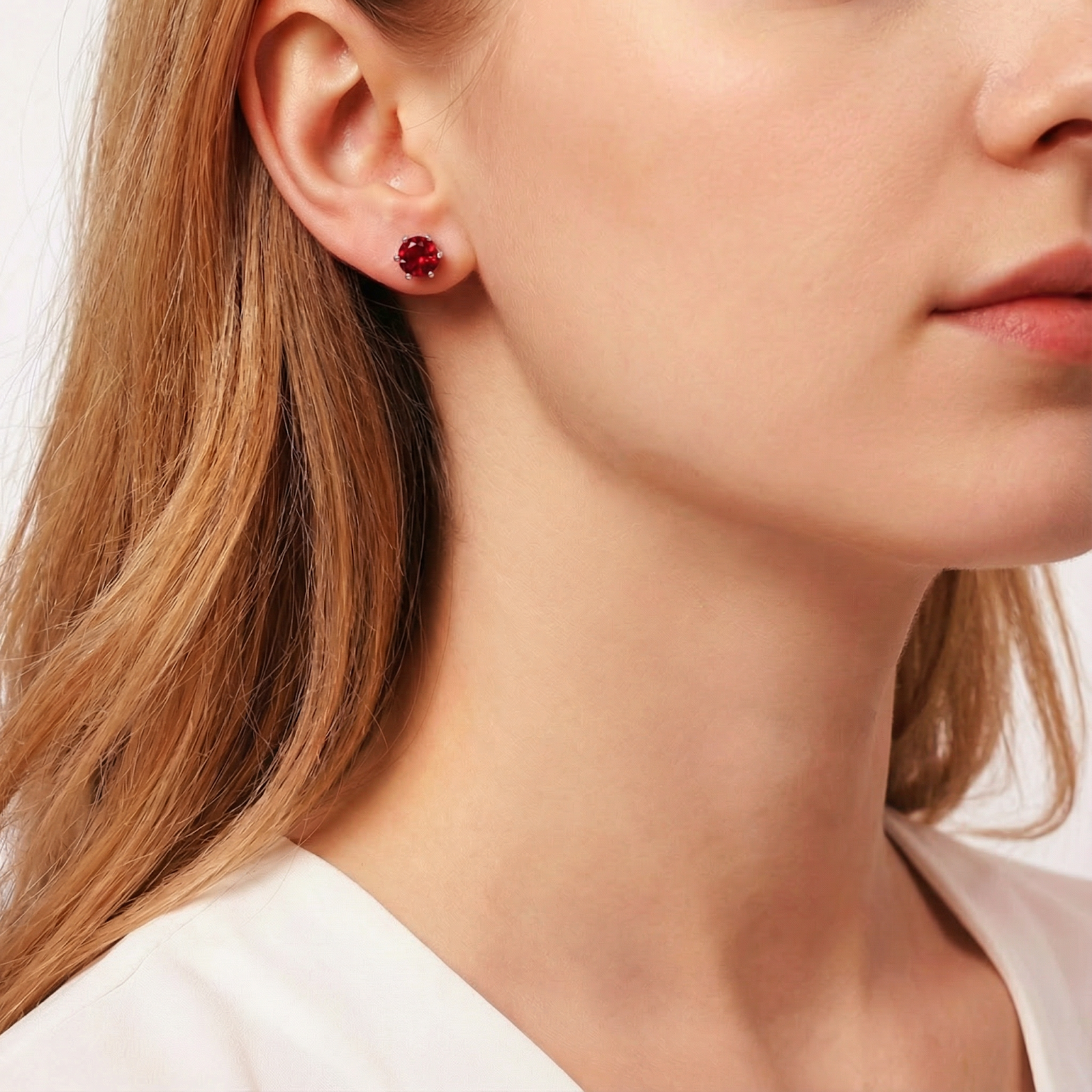 Model wearing a round cut red simulated ruby stud earring in S925 sterling silver.