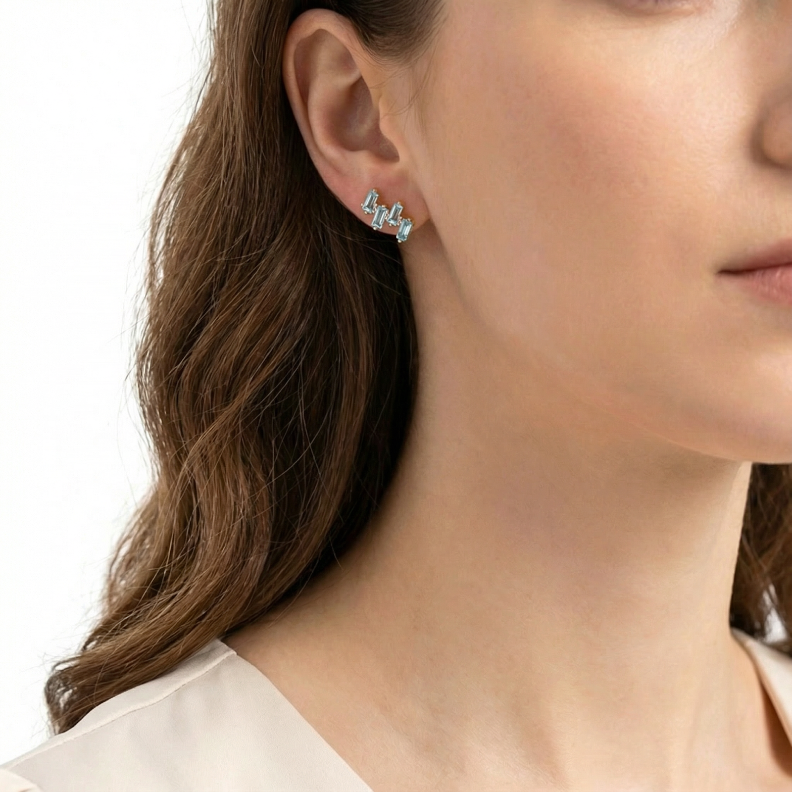Model wearing the Lyraea Cluster earring in 18K gold vermeil with blue simulated aquamarine stones.