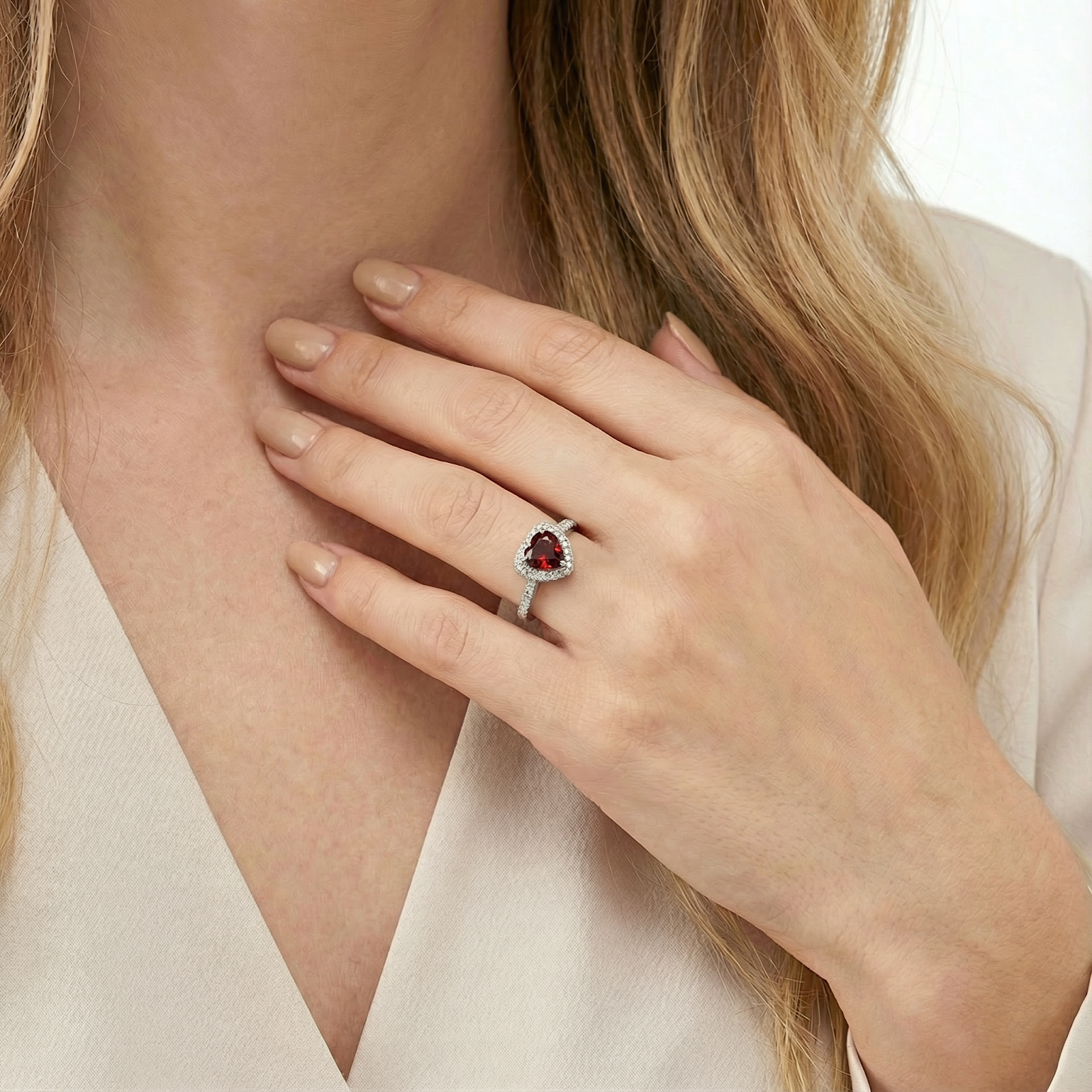 Close-up of the heart-cut simulated garnet S925 sterling silver ring on a model's finger.