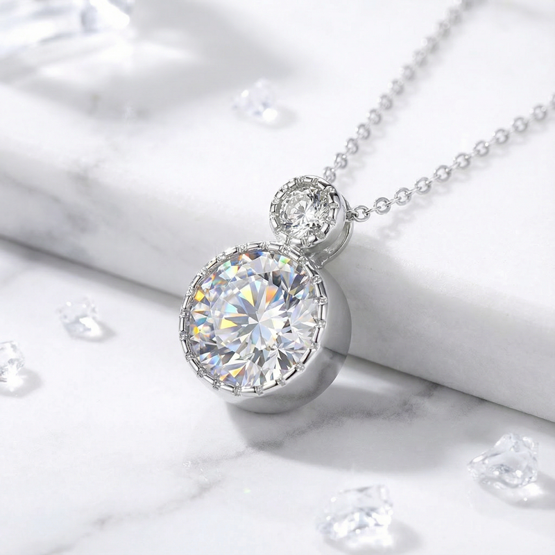 Frontal view of the sterling silver Luciana necklace with round-cut simulated diamonds on a marble surface.