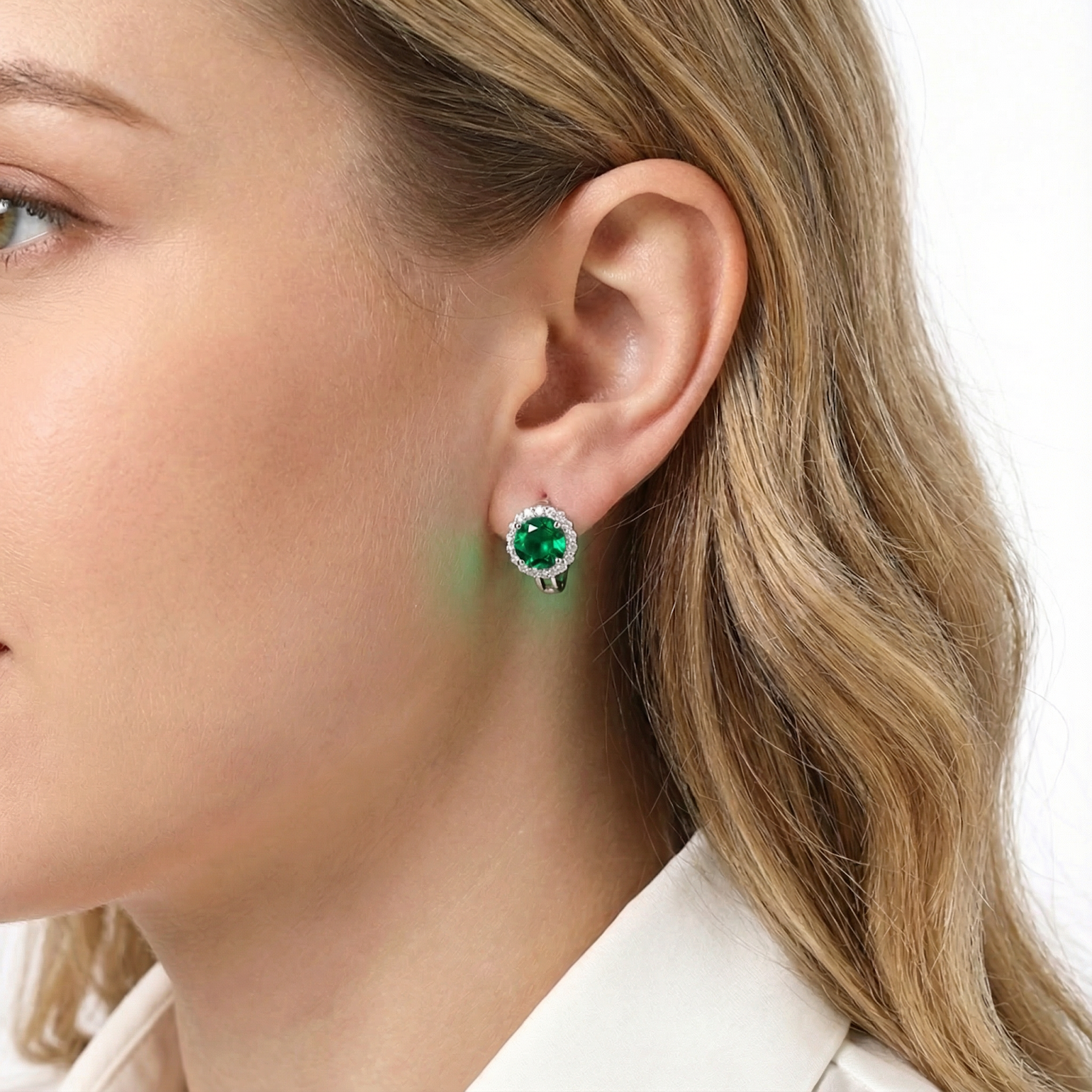 Sterling silver green moissanite halo stud earring worn on a model's ear.