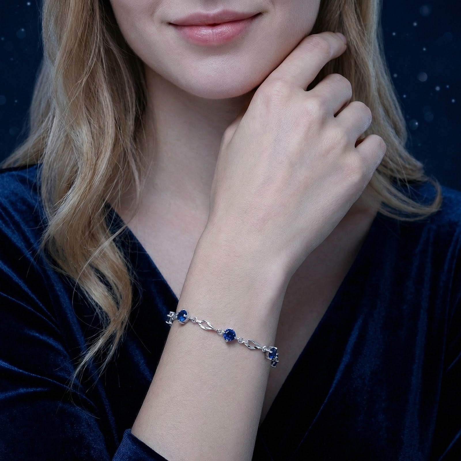 Nerienne sterling silver station bracelet with round blue sapphires worn on a woman's wrist.