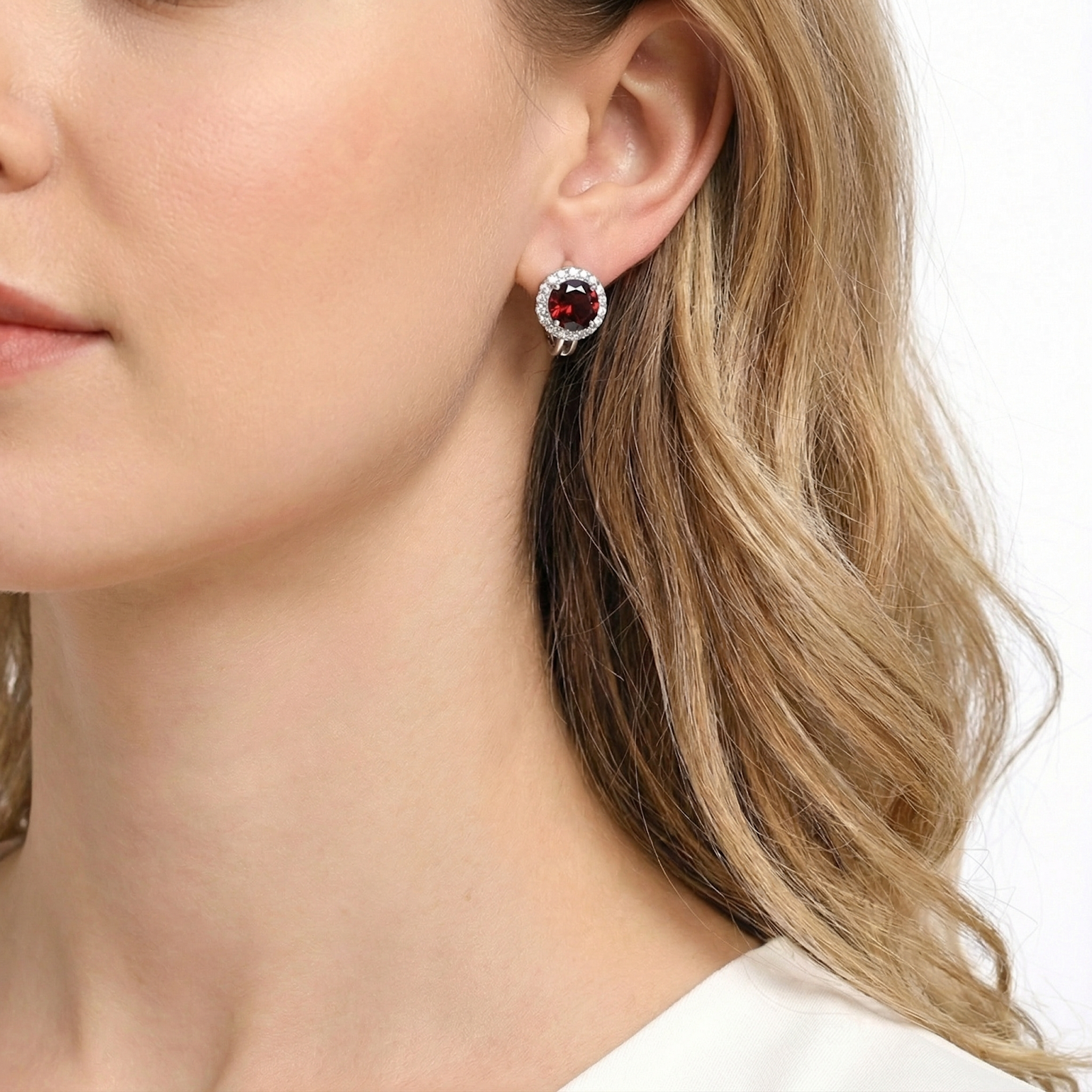 Side profile of a model wearing a round simulated garnet halo stud earring in S925 sterling silver.