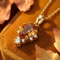Macro view of the pear-cut honey topaz and clear accent stones on an 18K gold vermeil necklace.