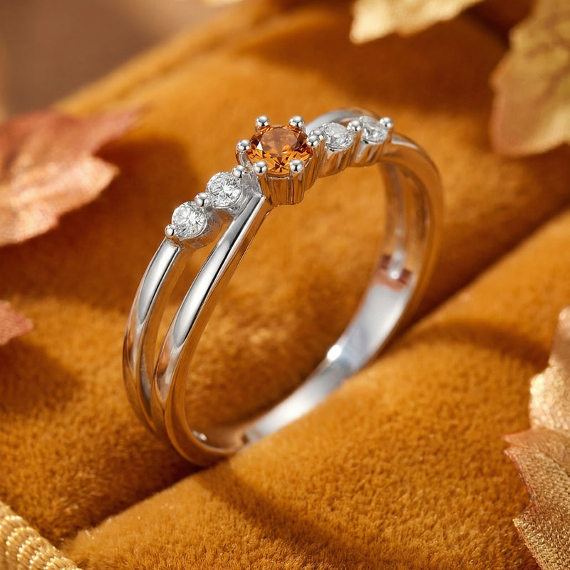 Macro side view of the sterling silver crossover ring showing the round simulated topaz and side accent stones.