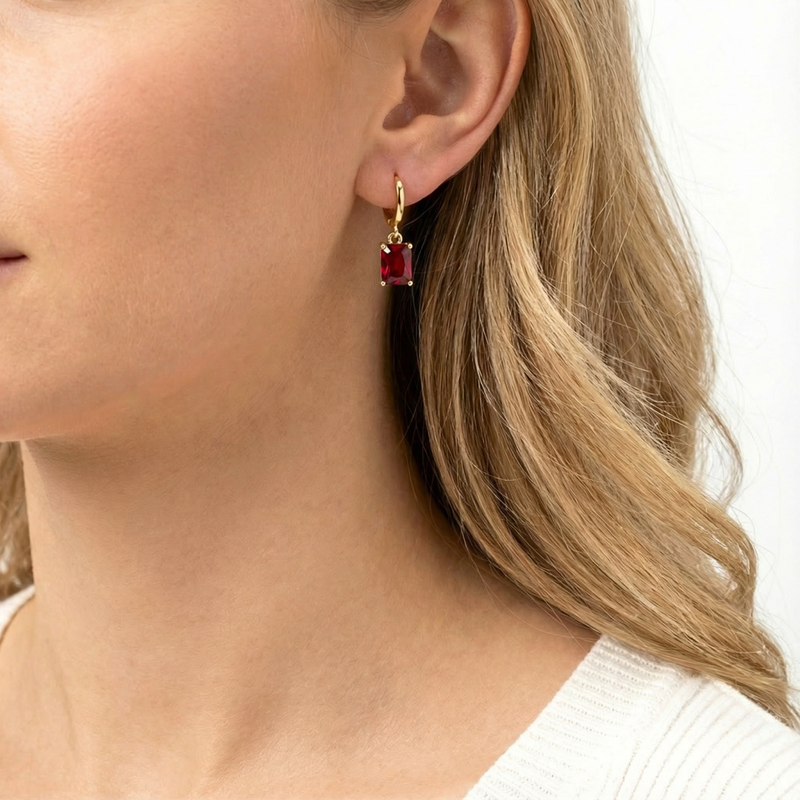 Profile of a model wearing the 18K gold vermeil hoop earring with a simulated ruby drop.