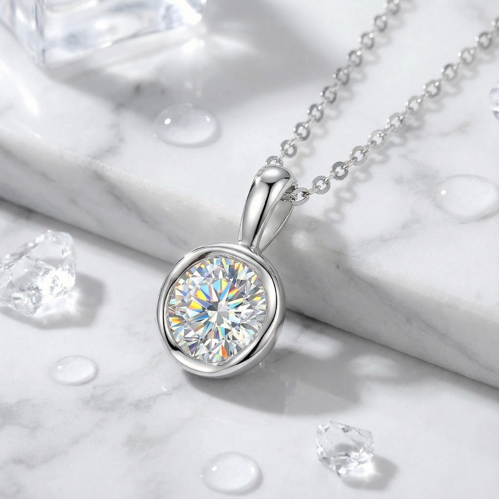 Round cut simulated diamond bezel necklace in sterling silver on a marble surface with water droplets.