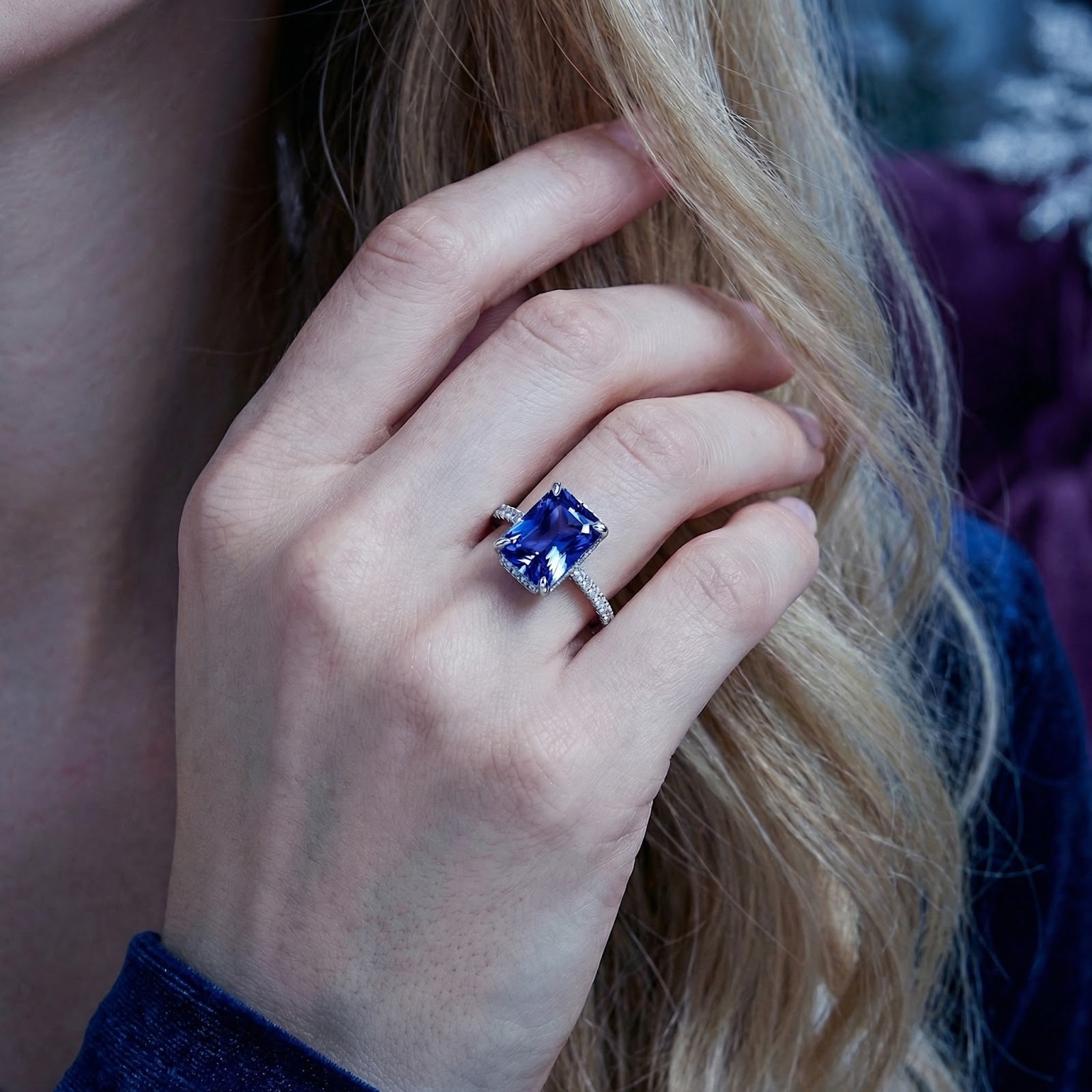 Radiant cut simulated tanzanite ring in S925 sterling silver worn on a woman's hand.