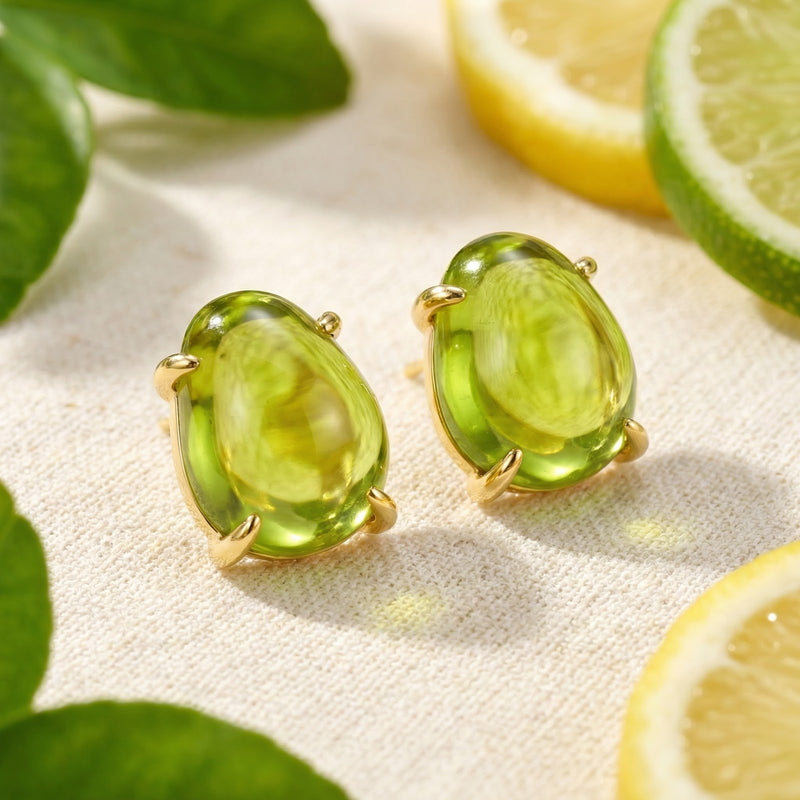 Angled view of Verdelle August birthstone simulated peridot cabochon earrings in 18K gold vermeil with lime slices.