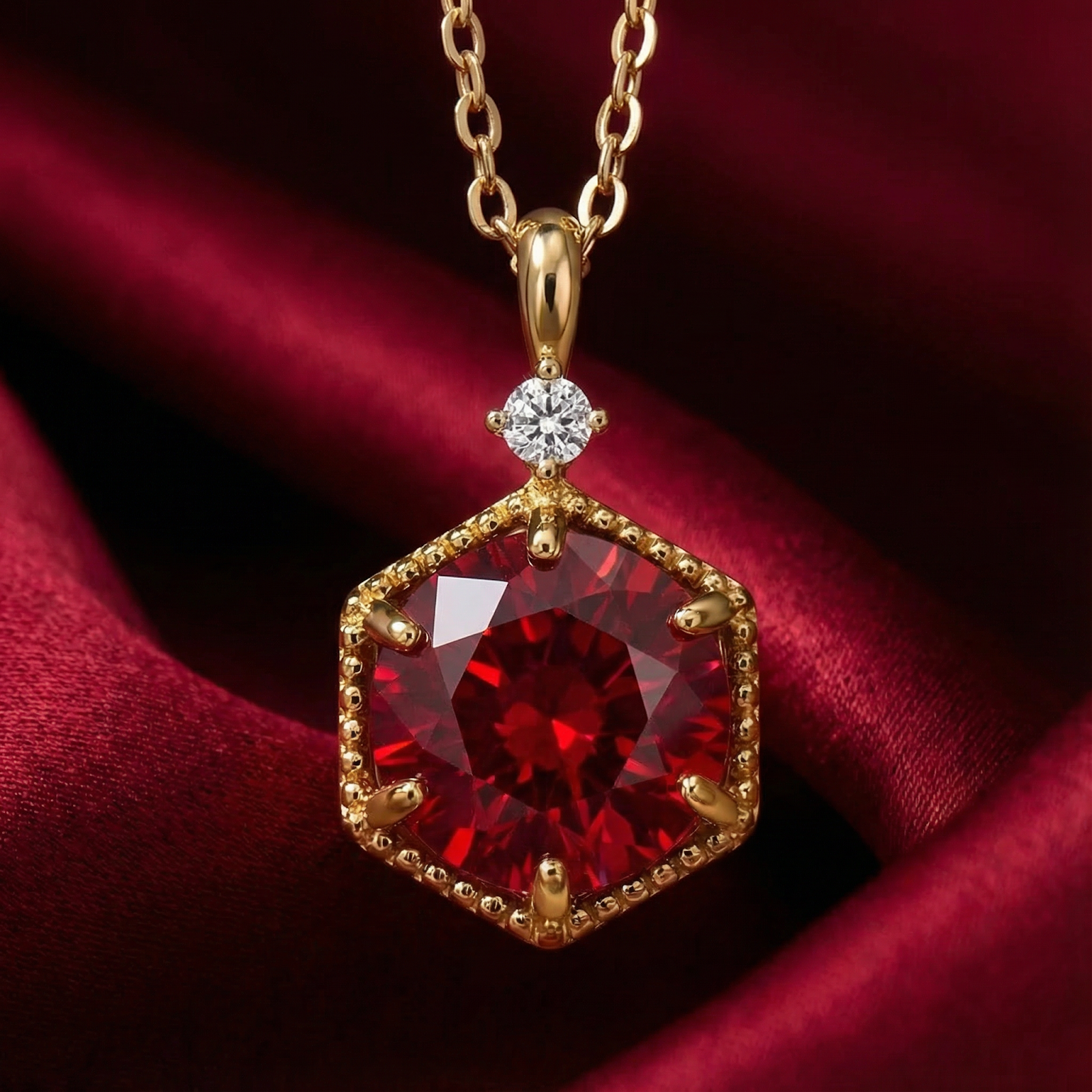 Hexagonal 18K gold vermeil necklace with a round-cut pigeon blood simulated ruby on red silk.