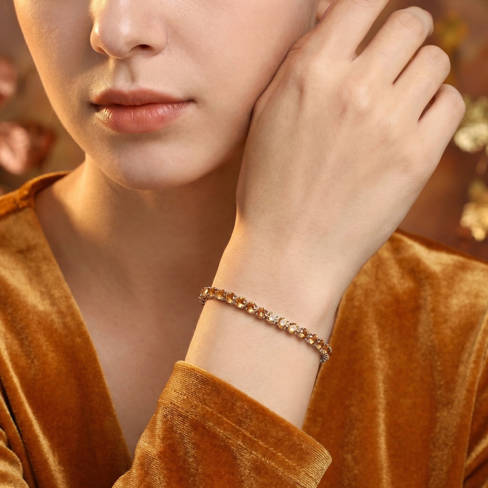 November birthstone simulated topaz tennis bracelet in stainless steel worn by a model in a velvet top.