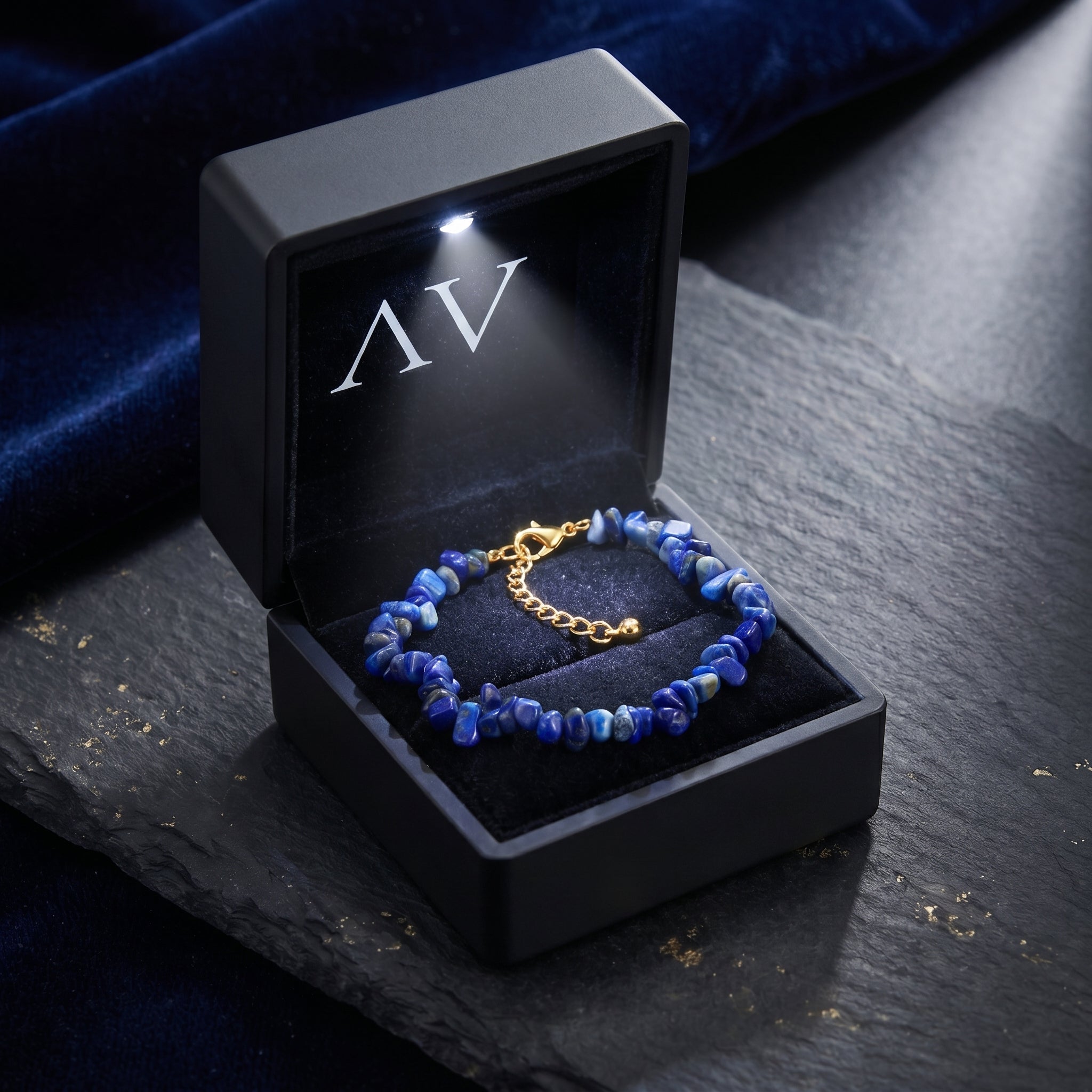 Lapis lazuli bead bracelet presented in a black lighted gift box with gold plated extender chain.