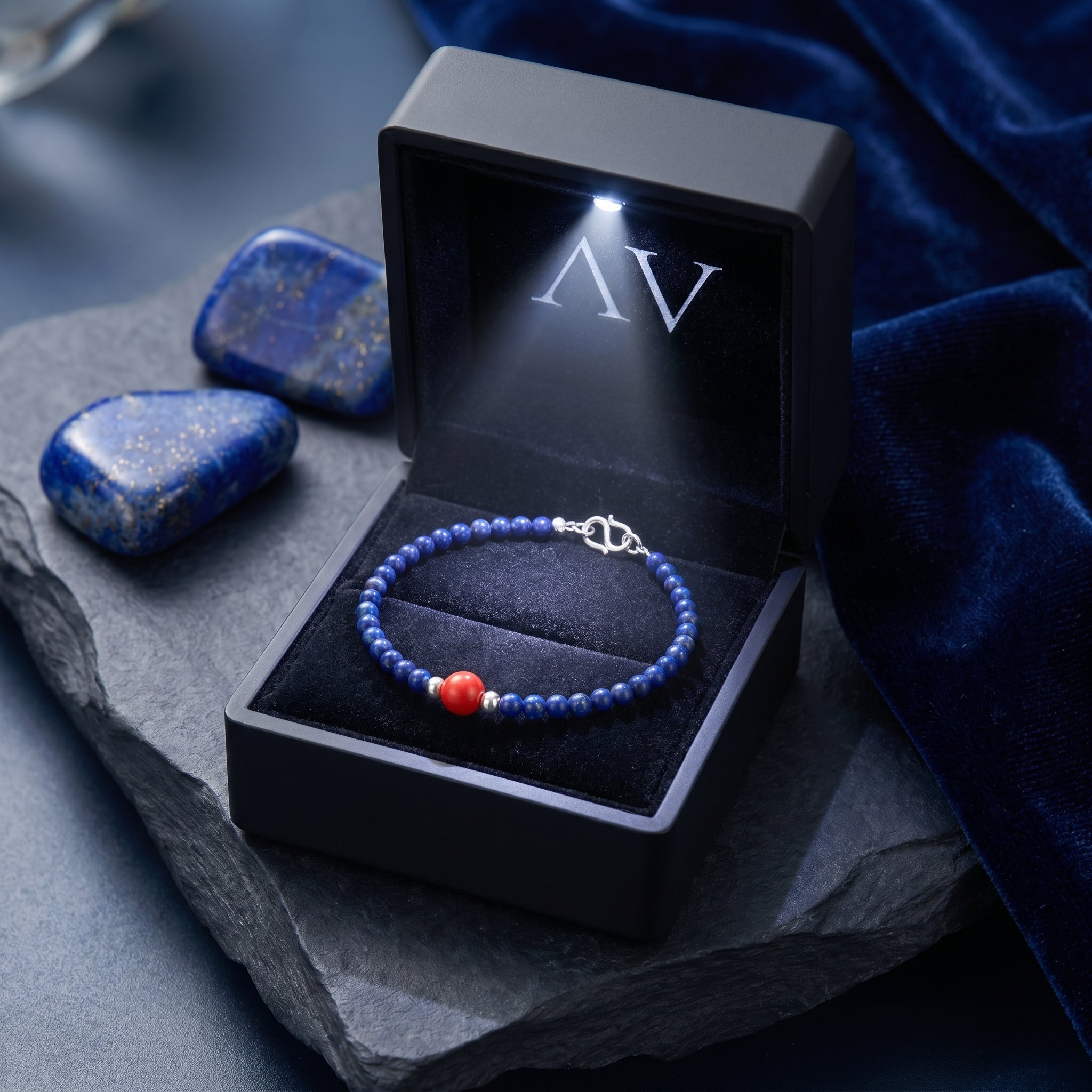 The Azure Trace lapis bracelet presented in a black illuminated gift box on a dark stone surface.