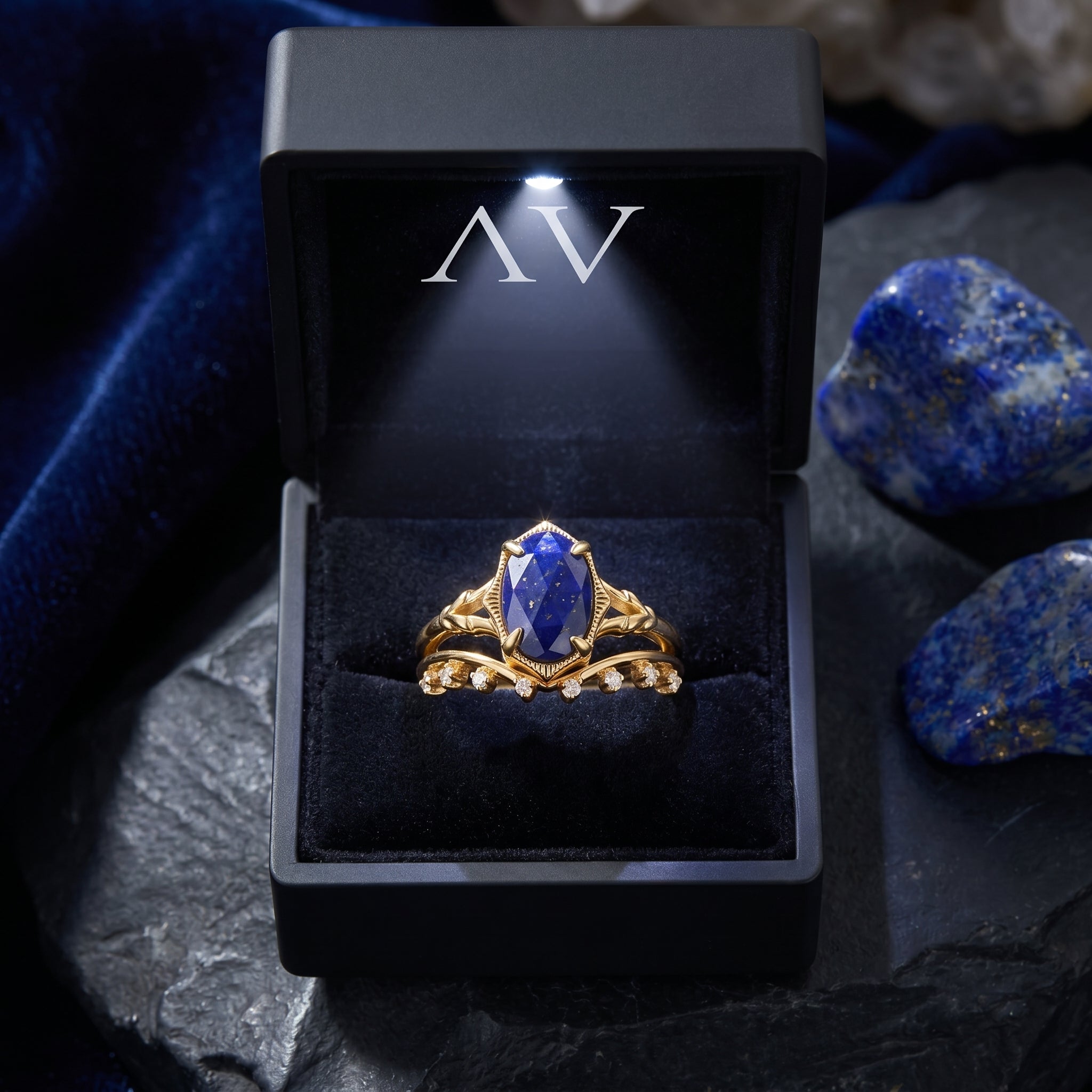 Gold plated silver oval lapis ring set presented in a black illuminated jewelry box.