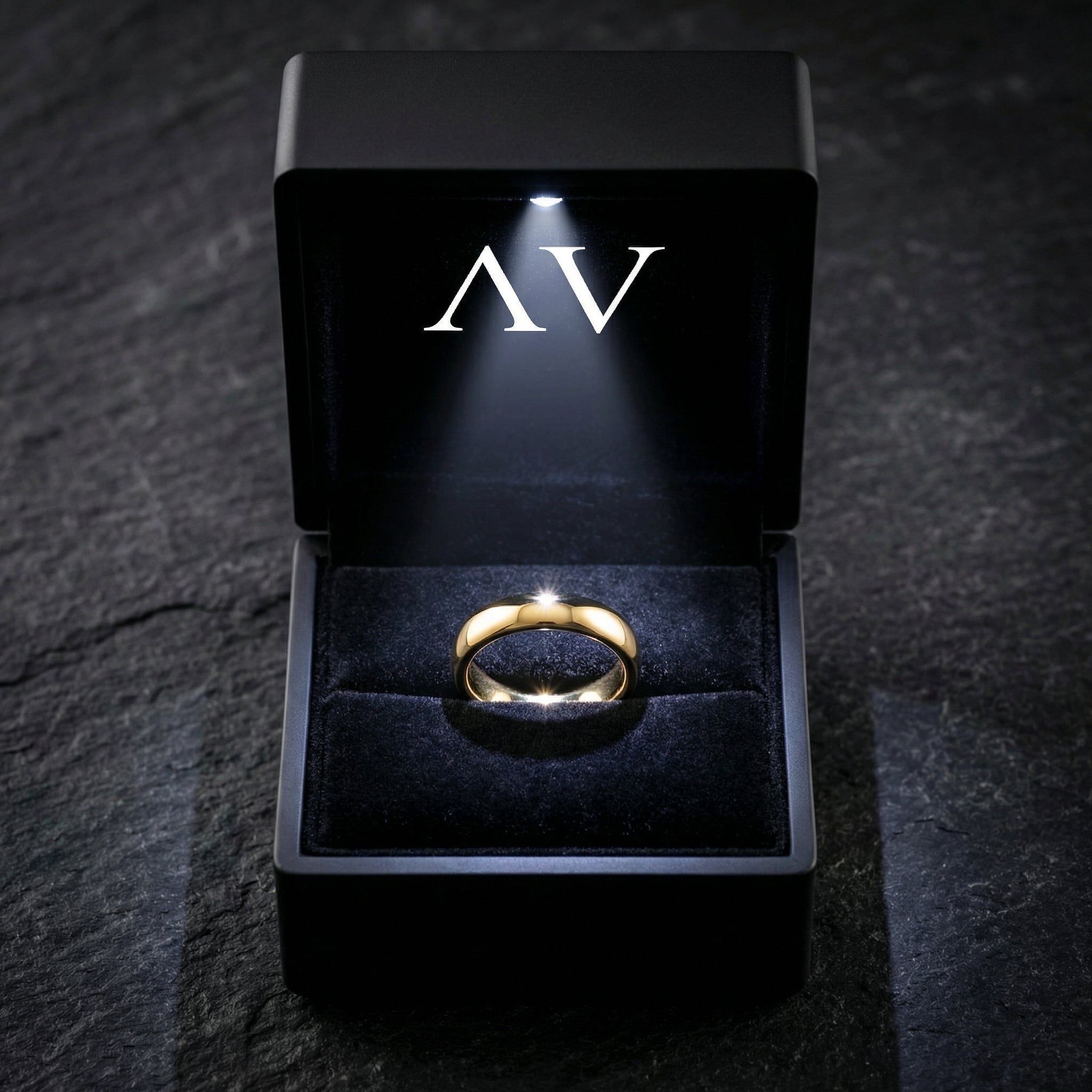 Gold tone stainless steel band ring presented in a black jewelry box with an integrated LED light.