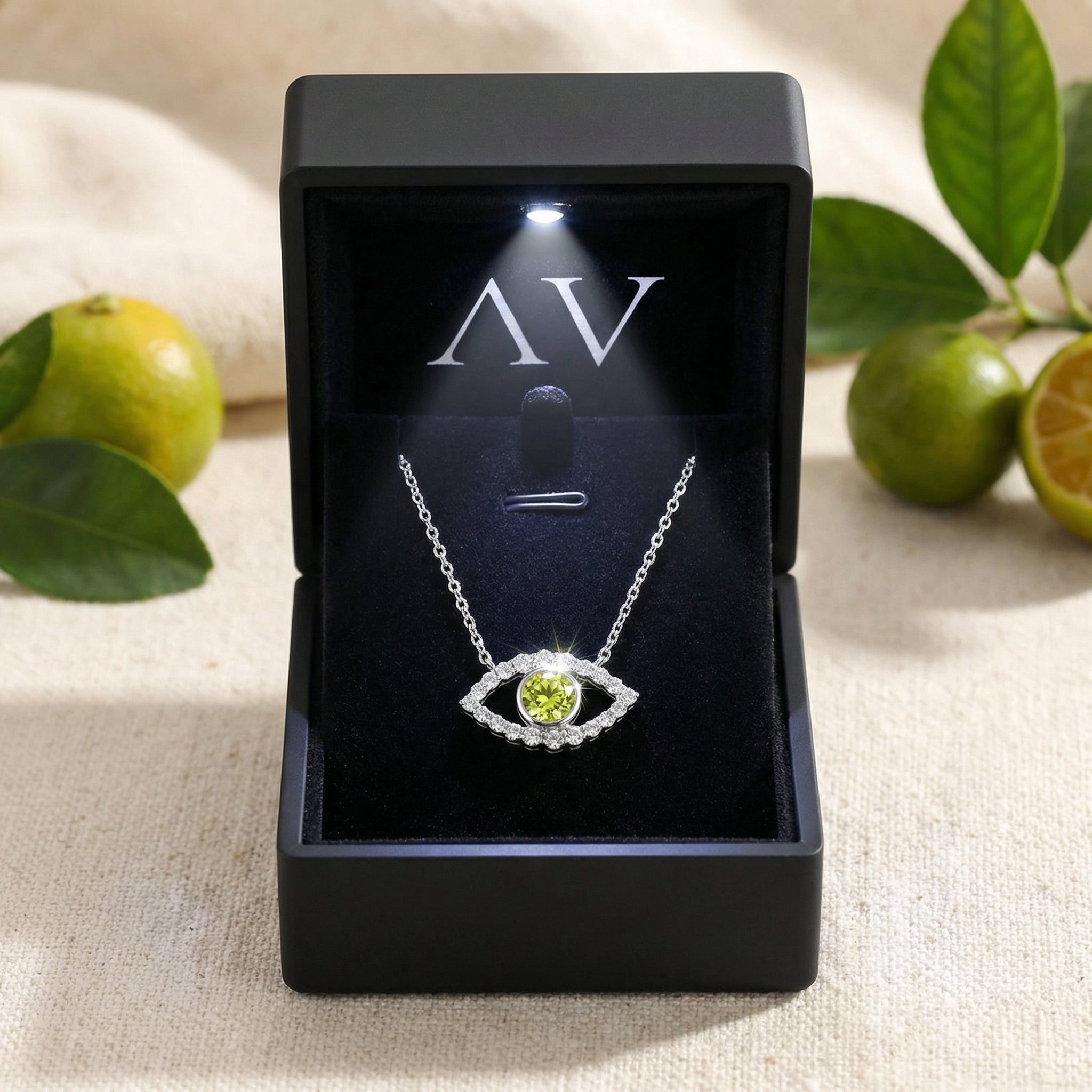 Silver eye necklace with yellow-green moissanite presented in a black LED-lit jewelry gift box.