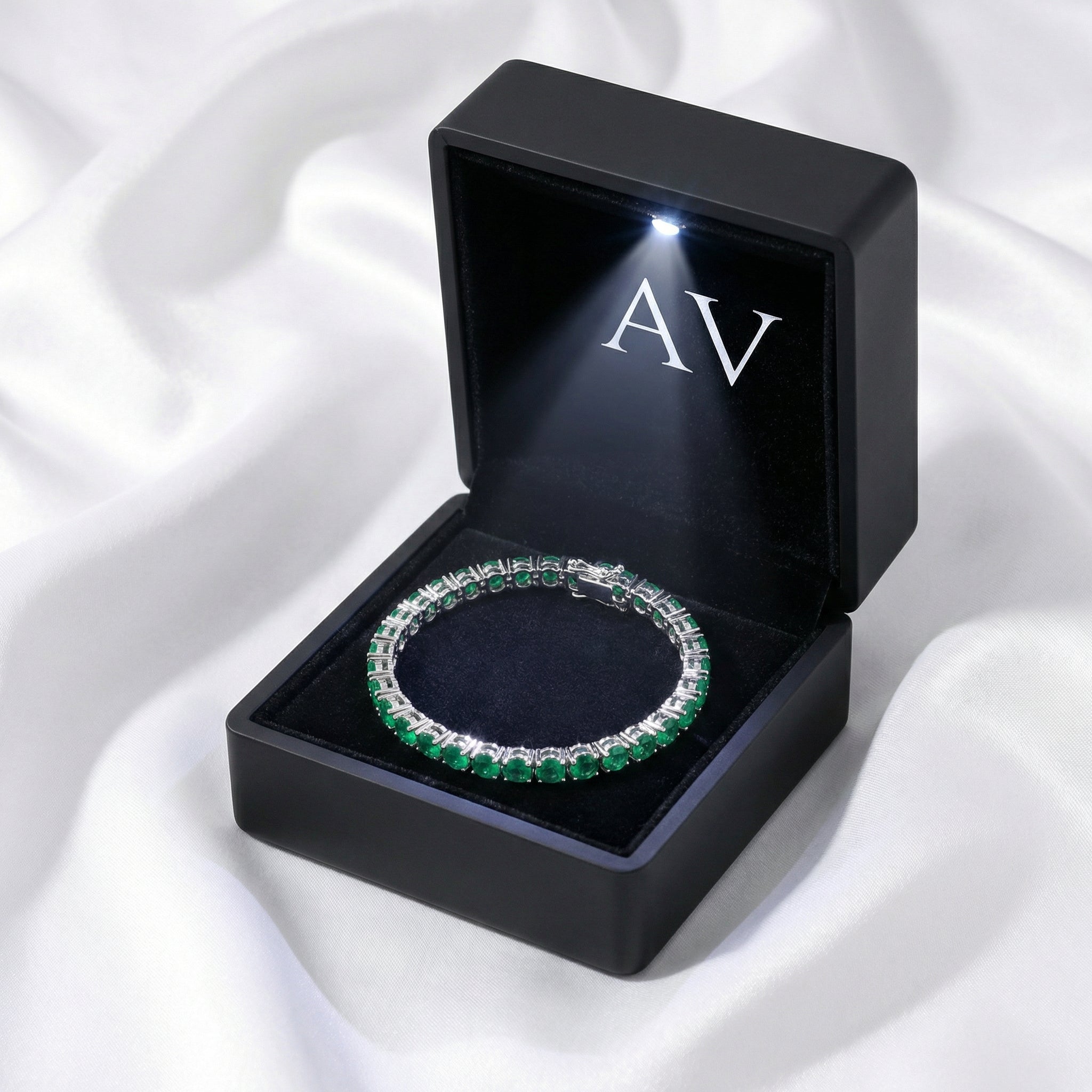 Vesperine simulated emerald tennis bracelet in a black LED-lit presentation gift box.