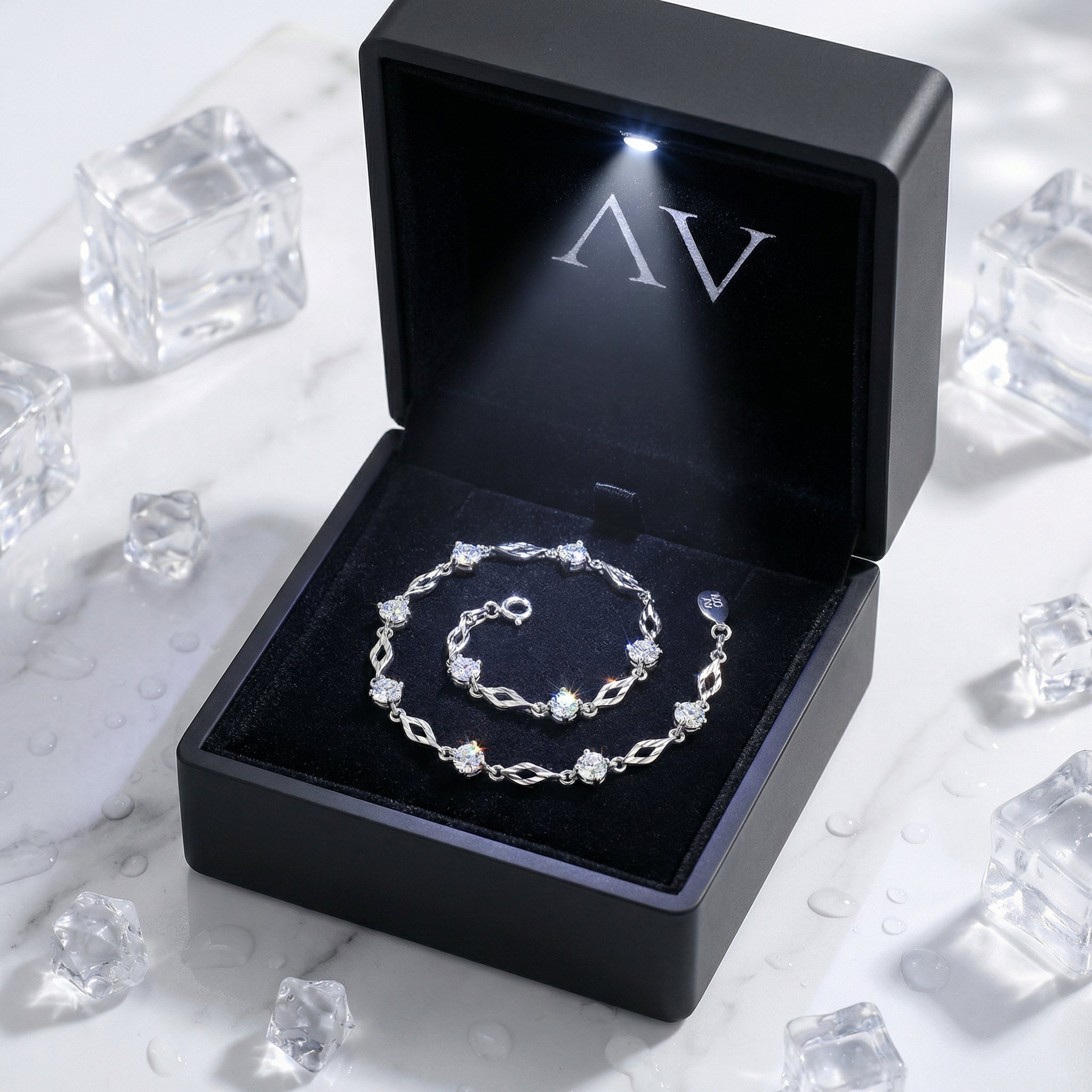 Sterling silver simulated diamond station bracelet displayed in a black LED-lit jewelry presentation box.