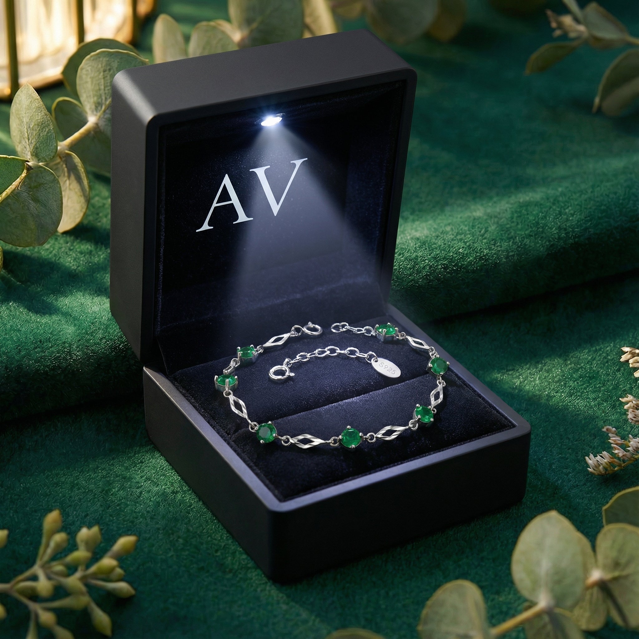 Sterling silver emerald station bracelet inside a lighted black AV branded jewelry gift box.