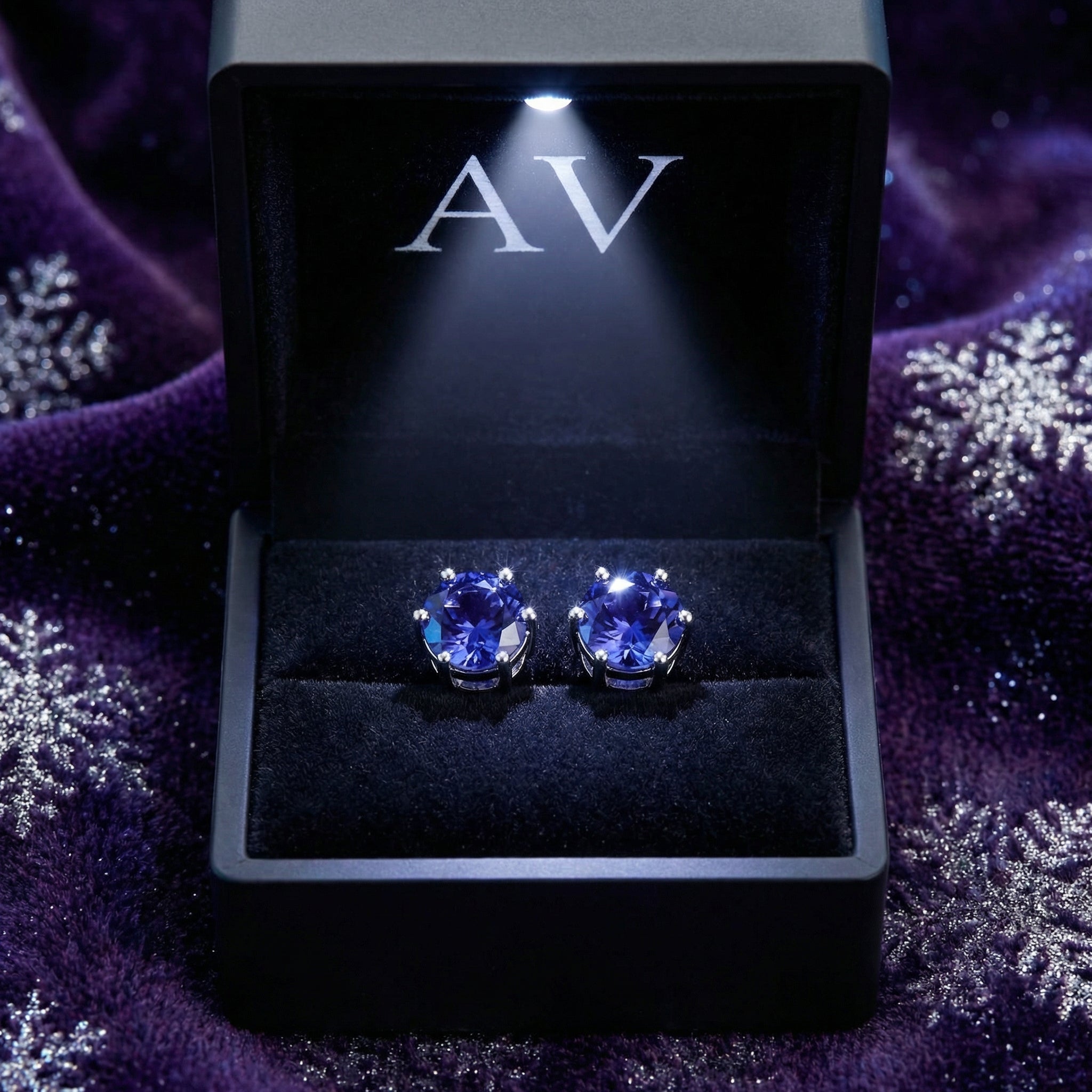 Simulated tanzanite stud earrings in sterling silver presented in a lighted black AV jewelry gift box.