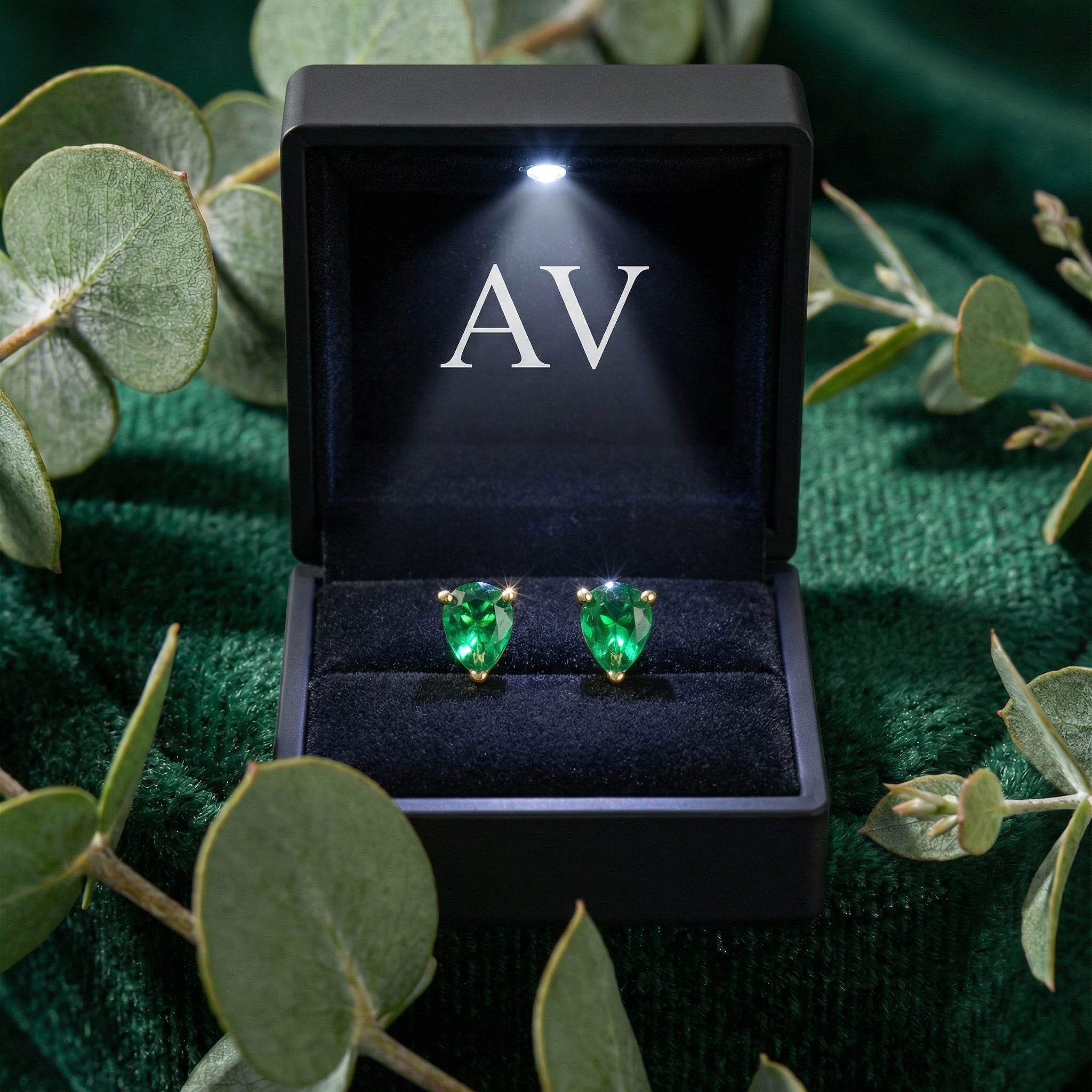 Pear-cut simulated emerald earrings in 18K gold vermeil inside a lighted black jewelry presentation box.