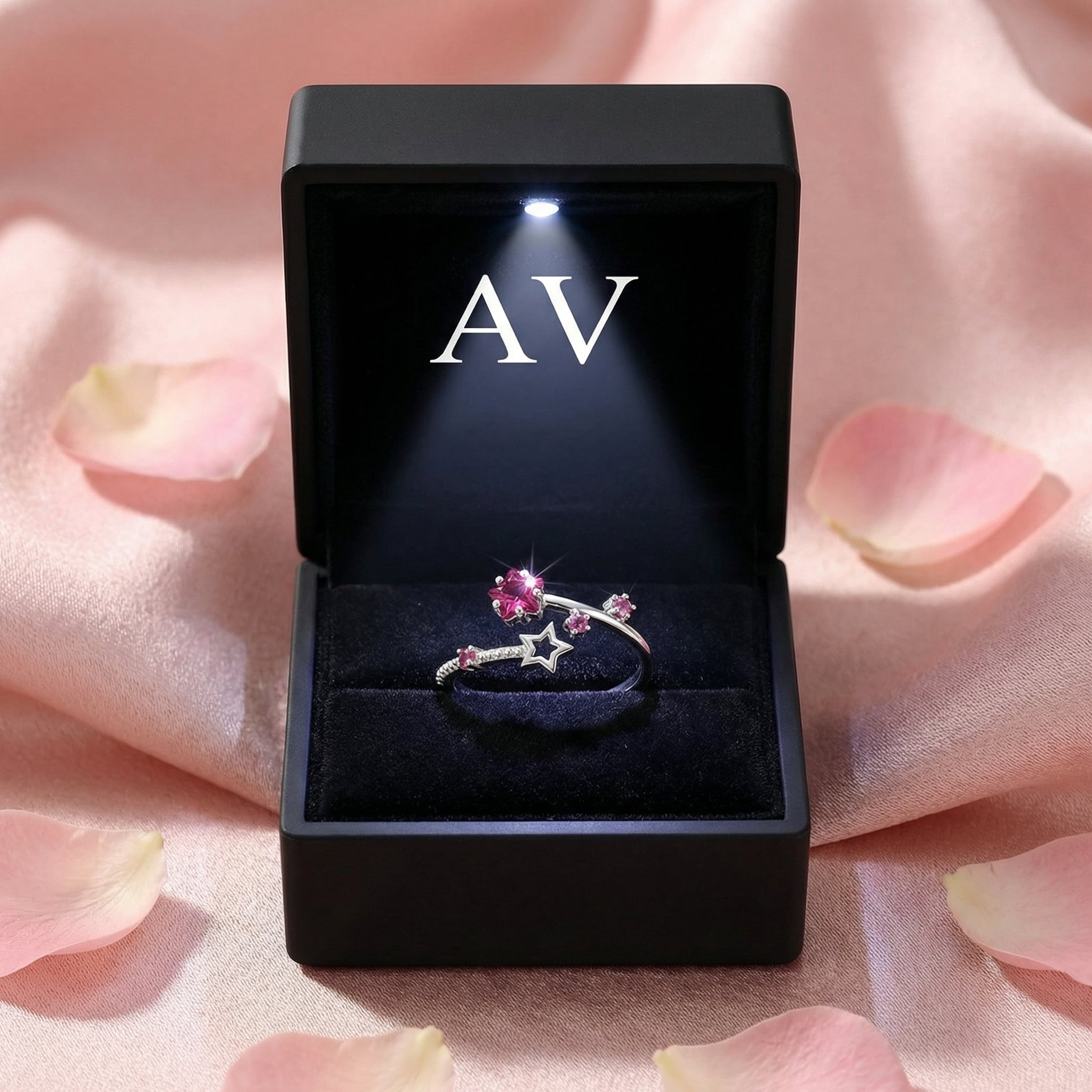 Pink tourmaline bypass ring presented in a black LED-lit jewelry gift box on a pink fabric background.
