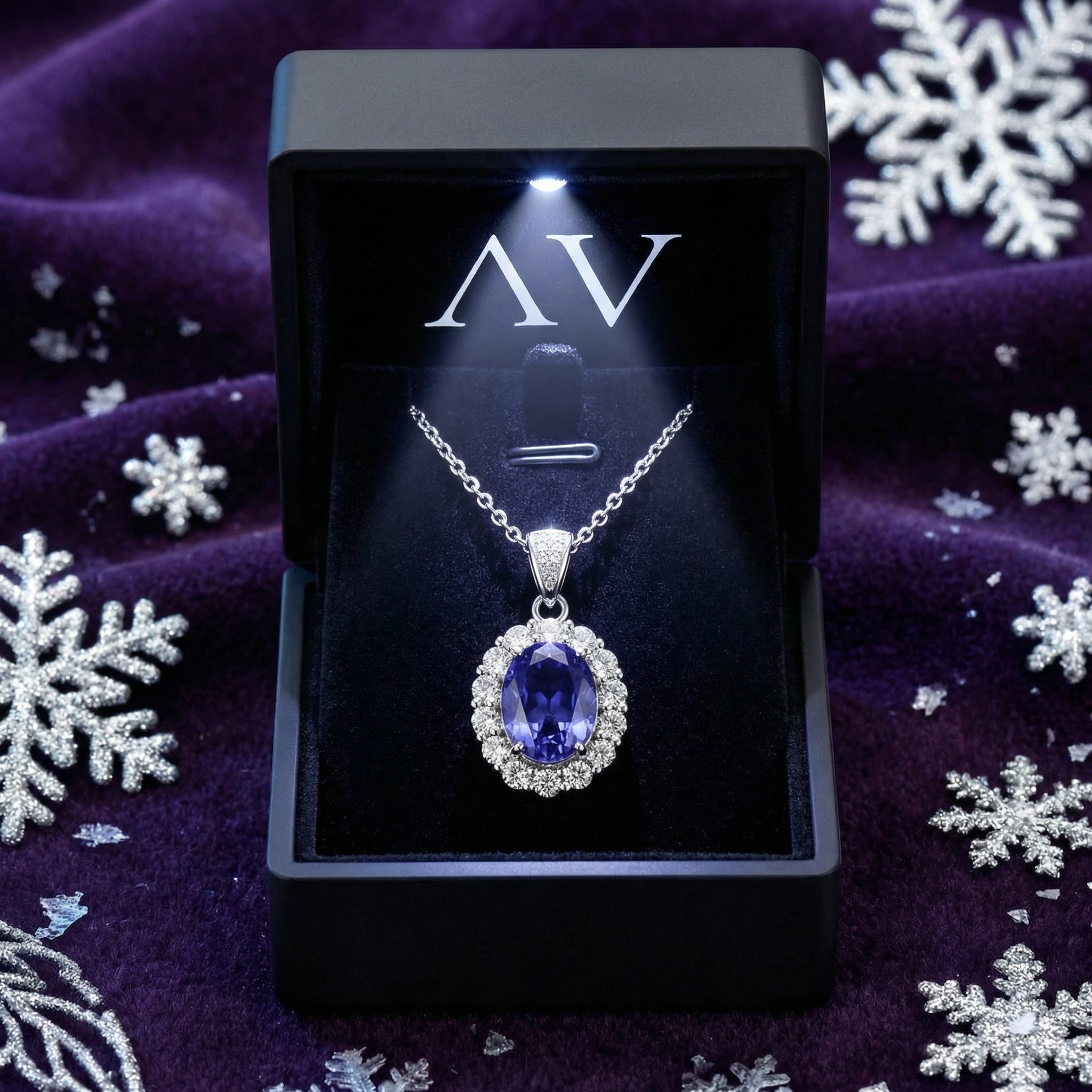 Sterling silver simulated tanzanite halo necklace in a lighted black gift box on a purple velvet background.