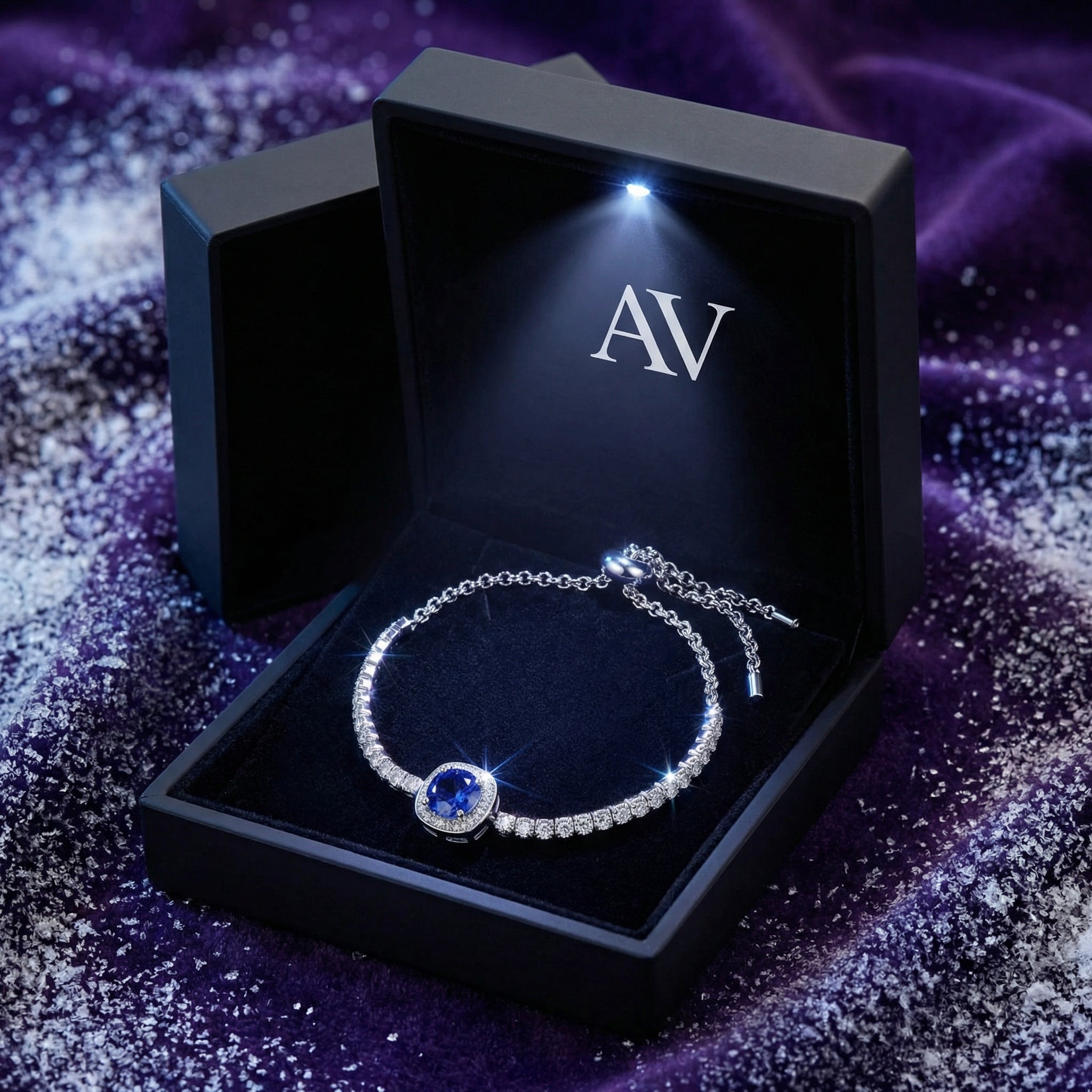 Blue simulated tanzanite halo bracelet inside a black LED-lit jewelry gift box with AV branding.