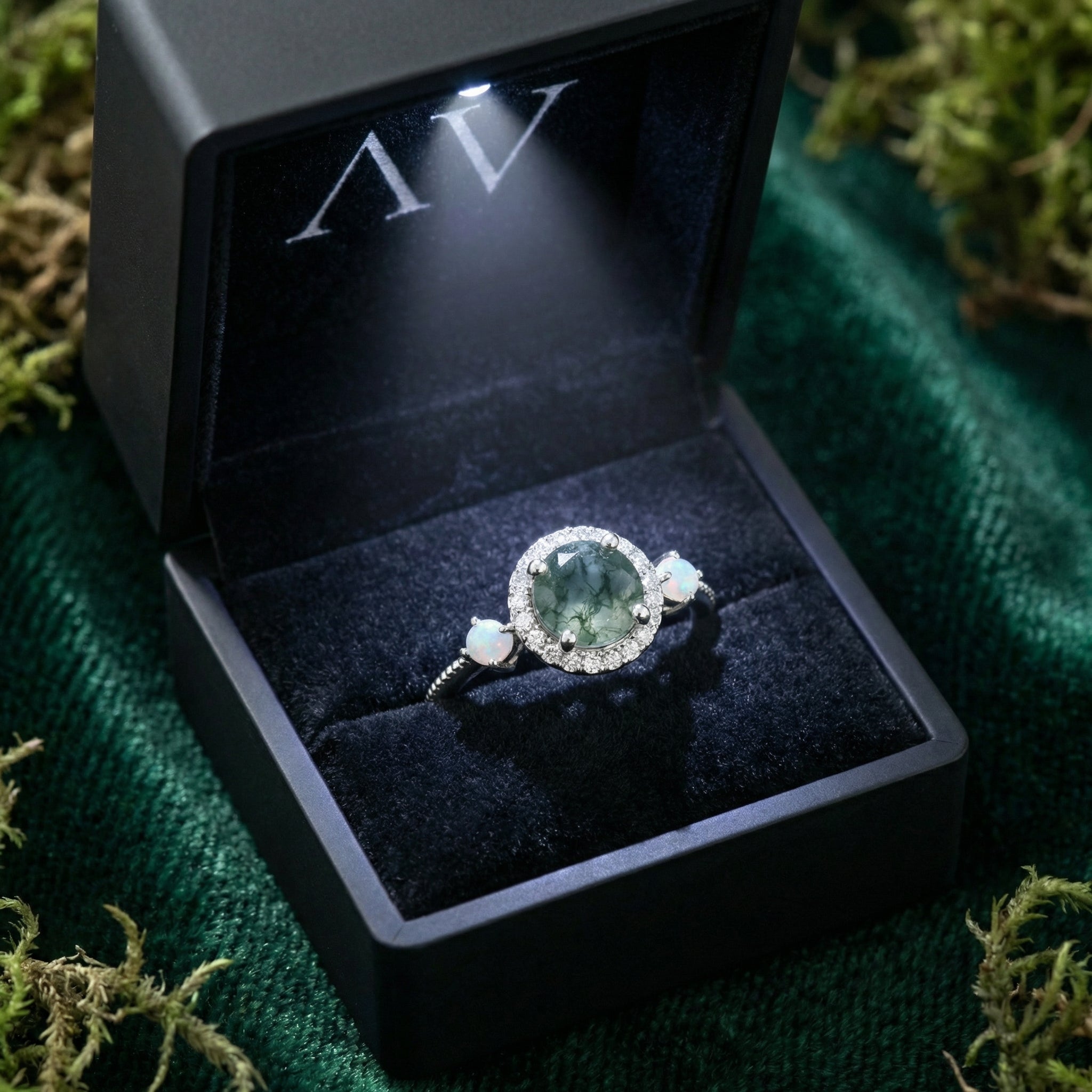 Round cut moss agate halo ring in S925 sterling silver presented in a lighted black gift box.