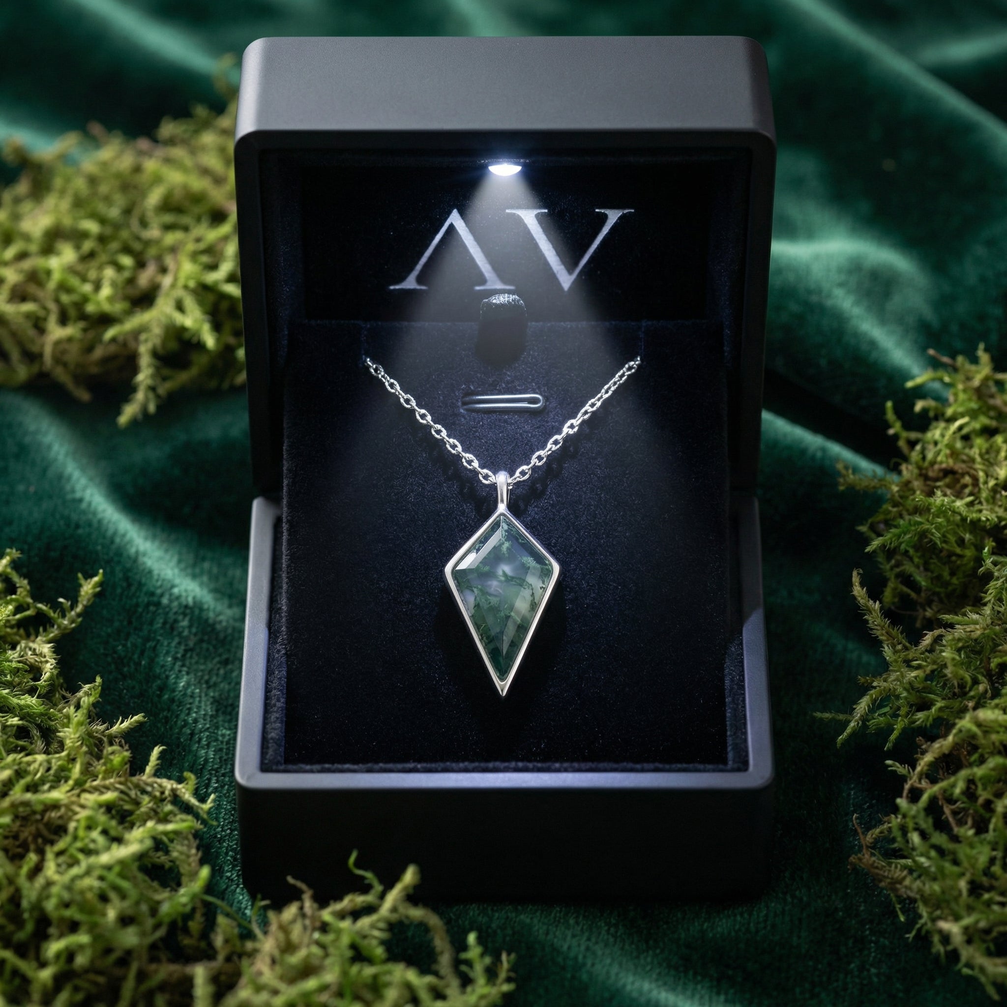 Kite cut moss agate necklace in S925 sterling silver presented in a black LED-lit gift box on green velvet.