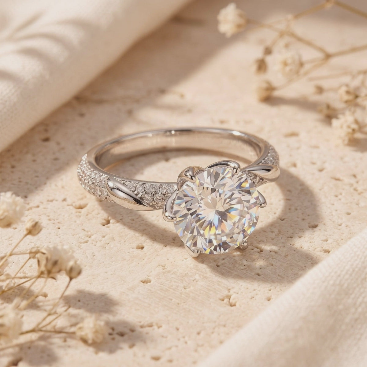 Neridelle ring resting on a light textured surface, showing its round center stone and twisted pavé band.