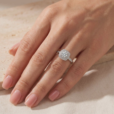 The Juliette Ring worn on a hand, showing its round center stone and square double halo with pavé accents.