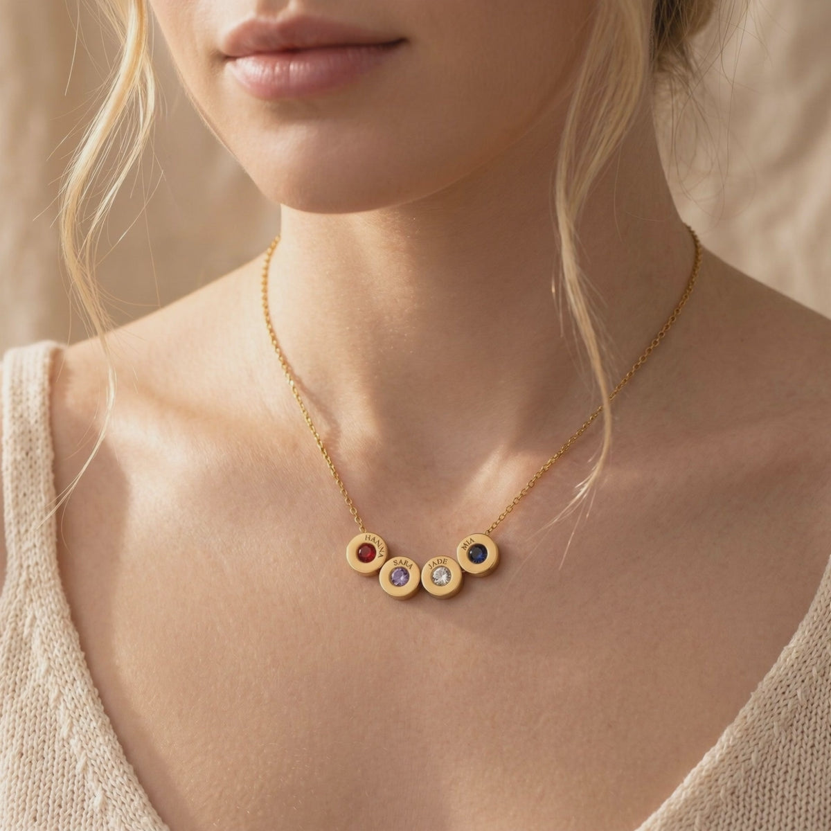 Gold Lucenna necklace with four engraved name charms and simulated birthstones worn on a model.
