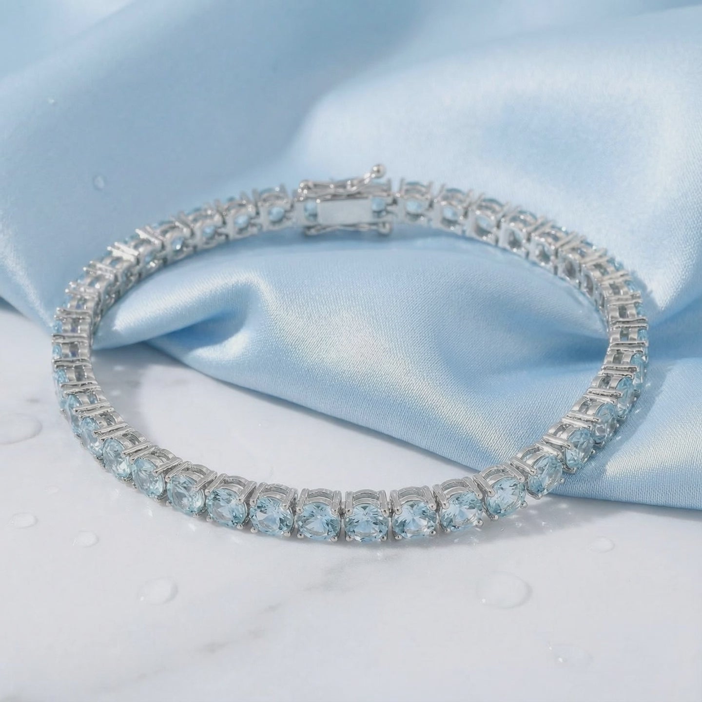 Simulated aquamarine tennis bracelet in solid gold.