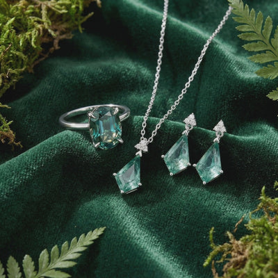 A solid gold jewelry set with green moissanite and moss agate.