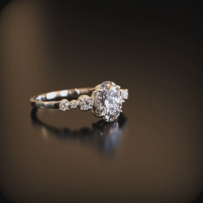 A solid gold ring with an oval moissanite center stone and round side stones.