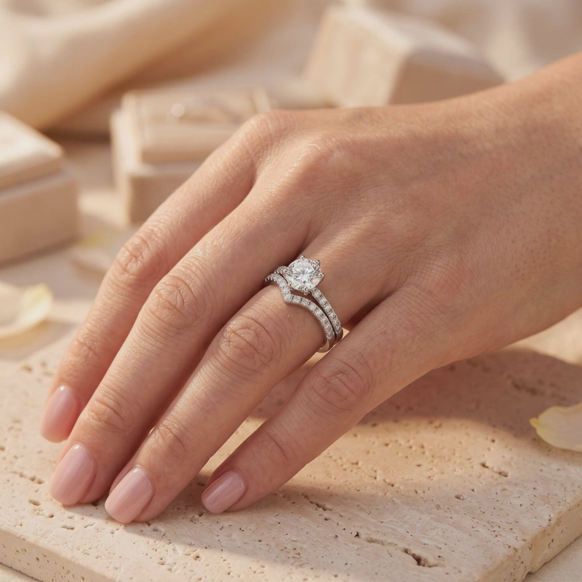 Sterling silver solitaire ring with a clear round stone and curved pavé band worn together on a hand.