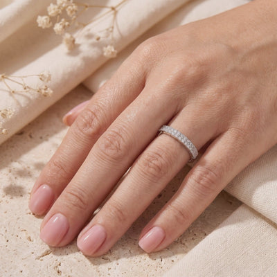 Rosalyssa silver double-row pavé ring worn on a finger against cream fabric and dried flowers.