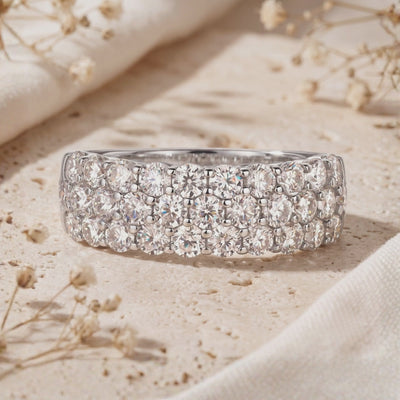 Close-up of a silver band ring featuring three rows of round pavé cubic zirconia.