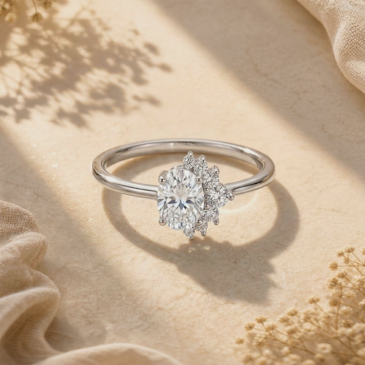 Video preview of a silver oval moissanite cluster ring shown flat against a warm textured background.